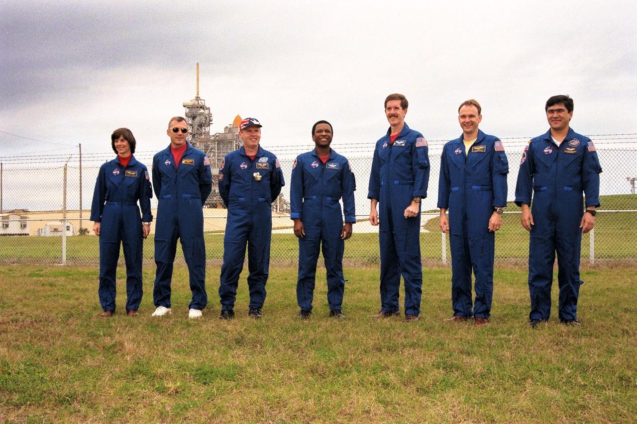 KENNEDY SPACE CENTER, Fla. -- STS-89 Mission Specialist Bonnie Dunbar, Ph.D.; Commander Terrence Wilcutt; Mission Specialists Andrew Thomas, Ph.D., Michael Anderson, James Reilly, Ph.D.; Pilot Joe Edwards Jr.; and Mission Specialist Salizhan Sharipov of the Russian Space Agency pose at KSC's Launch Pad 39A the day before the scheduled launch of Space Shuttle Endeavour. Final preparations are under way toward liftoff on Jan. 22 on the eighth mission to dock with the Russian Space Station Mir. After docking, Dr. Thomas will transfer to the space station, succeeding David Wolf, M.D., who will return to Earth aboard Endeavour. Dr. Thomas will live and work on Mir until June. STS-89 is scheduled for liftoff at 9:48 p.m. EST