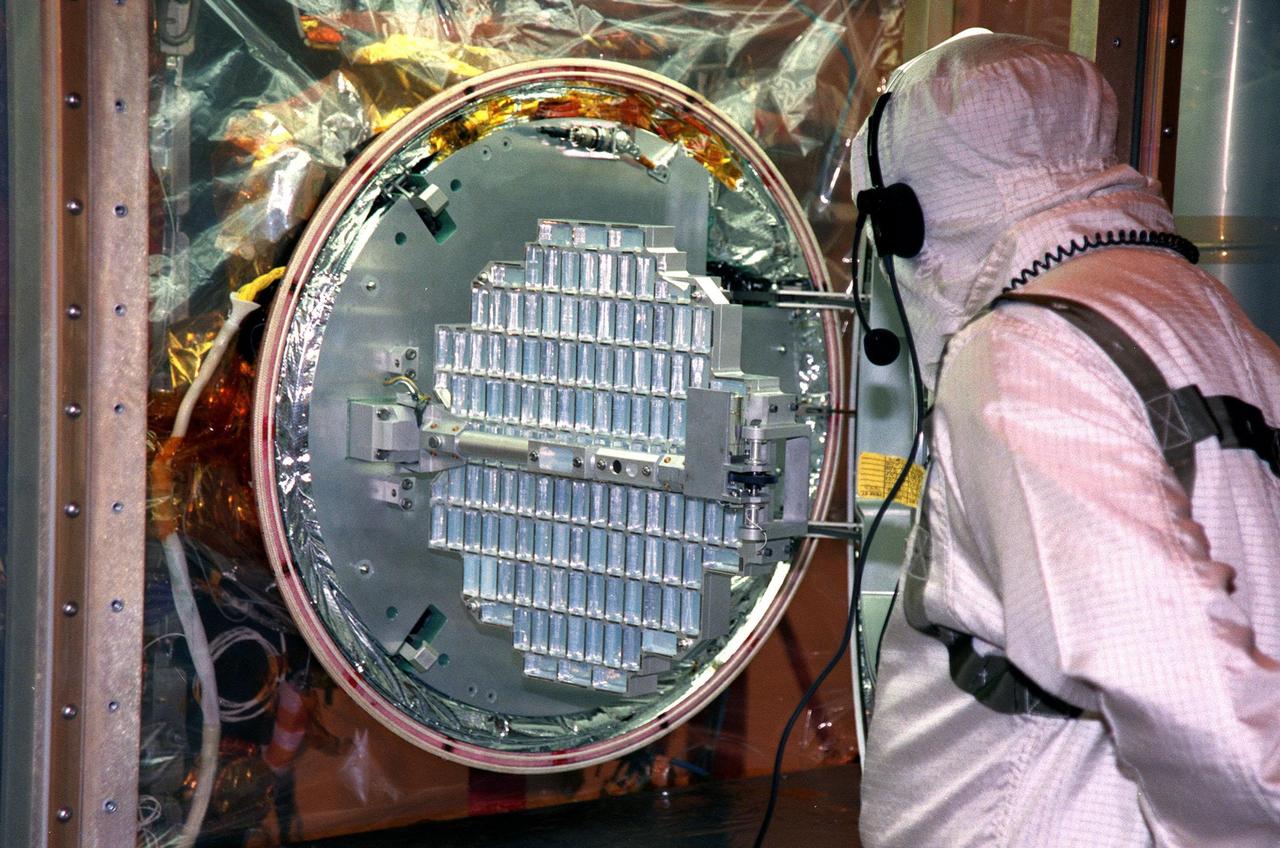 In the Payload Hazardous Servicing Facility, workers deploy an aerogel grid from the Stardust Sample Return Capsule (SRC) in the Class 100 Glove Box. Stardust will use a unique medium called aerogel to capture comet particles flying off the nucleus of comet Wild 2 in January 2004, plus collect interstellar dust for later analysis. The collected samples will return to Earth in the SRC to be jettisoned as it swings by Earth in January 2006. Stardust is scheduled to be launched aboard a Boeing Delta 7426 rocket from Complex 17, Cape Canaveral Air Station, on Feb. 6, 1999
