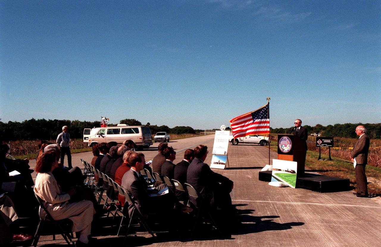 Center Director Roy Bridges, at the podium, speaks to federal and state elected officials during the ground breaking ceremony for a multi-purpose hangar, phase one of the Reusable Launch Vehicle (RLV) Support Complex to be built near the Shuttle Landing Facility. At right is Ed O'Connor, executive director of the Spaceport Florida Authority (SFA). The new complex is jointly funded by SFA, NASA's Space Shuttle Program and Kennedy Space Center. It is intended to support the Space Shuttle and other RLV land X-vehicle systems. Completion is expected by the year 2000