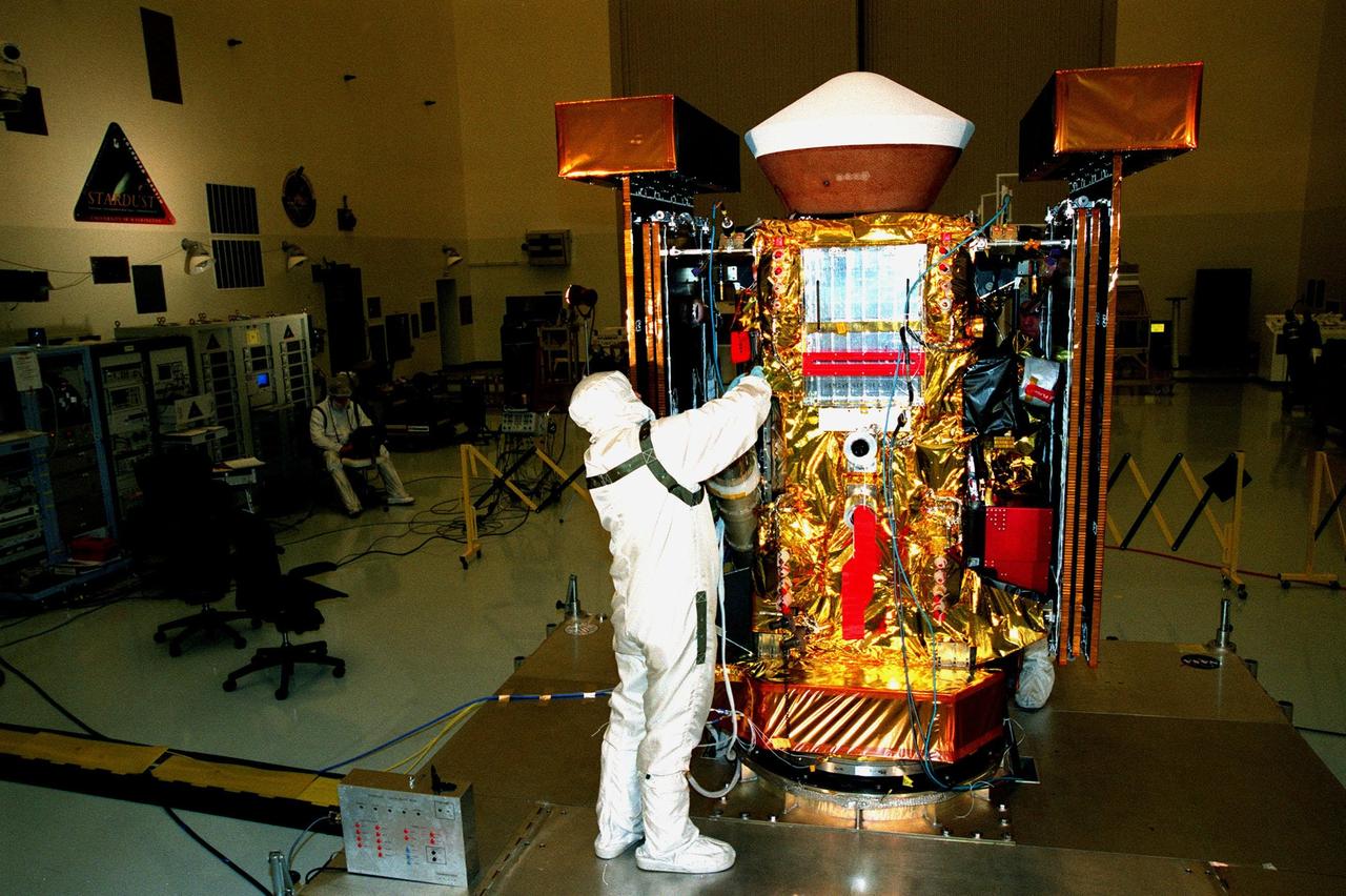 In the Payload Hazardous Servicing Facility, Randy Scott, with Lockheed Martin Astronautics, checks insulation material on the <a href="http://www-pao.ksc.nasa.gov/kscpao/captions/subjects/stardust.htm">Stardust</a> spacecraft. Stardust will use a unique medium called aerogel to capture comet particles flying off the nucleus of comet Wild 2 in January 2004, plus collect interstellar dust for later analysis. The collected samples will return to Earth in the SRC to be jettisoned as it swings by Earth in January 2006. Stardust is scheduled to be launched aboard a Boeing Delta 7426 rocket from Complex 17, Cape Canaveral Air Station, on Feb. 6, 1999