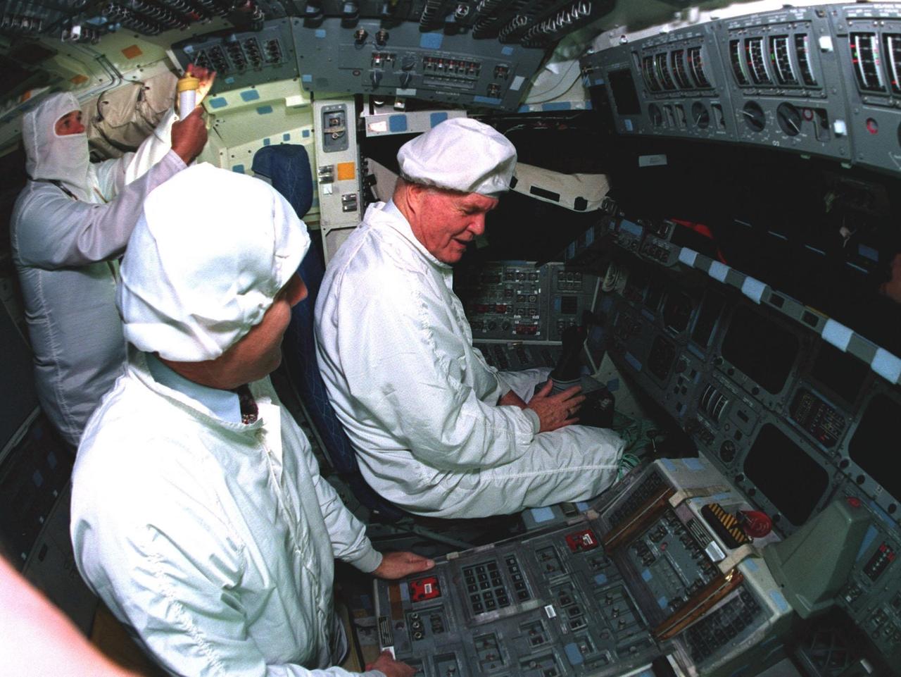Ohio Senator John Glenn, at right, sits in the flight deck of the orbiter Columbia as astronaut Stephen Oswald listens to his questions regarding some of the flight equipment at the Orbiter Processing Facility 3 at Kennedy Space Center. Senator Glenn arrived at KSC on Jan. 20 to tour KSC operational areas and to view the launch of STS-89 later this week. Glenn, who made history in 1962 as the first American to orbit the Earth, completing three orbits in a five-hour flight aboard Friendship 7, will fly his second space mission aboard Space Shuttle Discovery this October. Glenn is retiring from the Senate at the end of this year and will be a payload specialist aboard STS-95