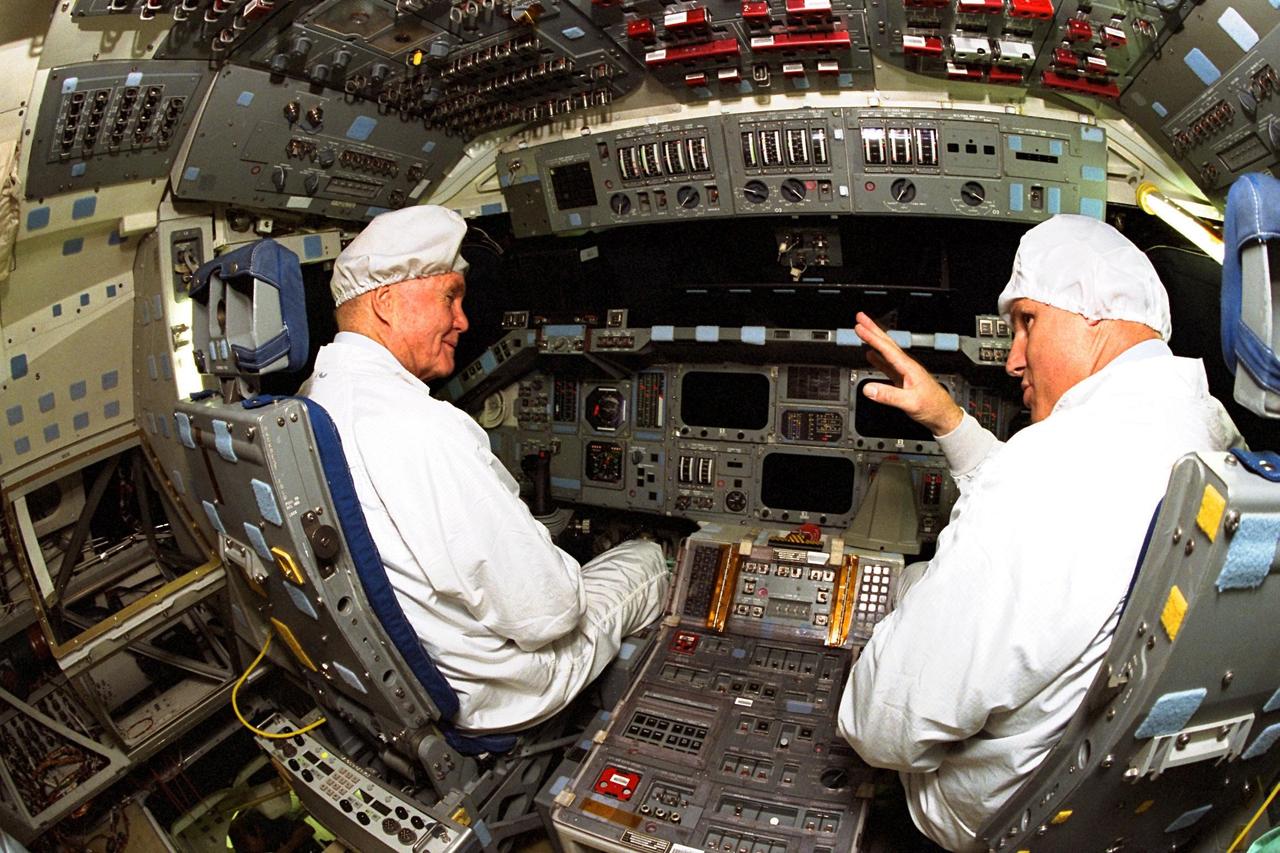 Ohio Senator John Glenn, at left, sits in the flight deck of the orbiter Columbia as astronaut Stephen Oswald explains some of the flight equipment to the senator at the Orbiter Processing Facility 3 at Kennedy Space Center. Senator Glenn arrived at KSC on Jan. 20 to tour KSC operational areas and to view the launch of STS-89 later this week. Glenn, who made history in 1962 as the first American to orbit the Earth, completing three orbits in a five-hour flight aboard Friendship 7, will fly his second space mission aboard Space Shuttle Discovery this October. Glenn is retiring from the Senate at the end of this year and will be a payload specialist aboard STS-95