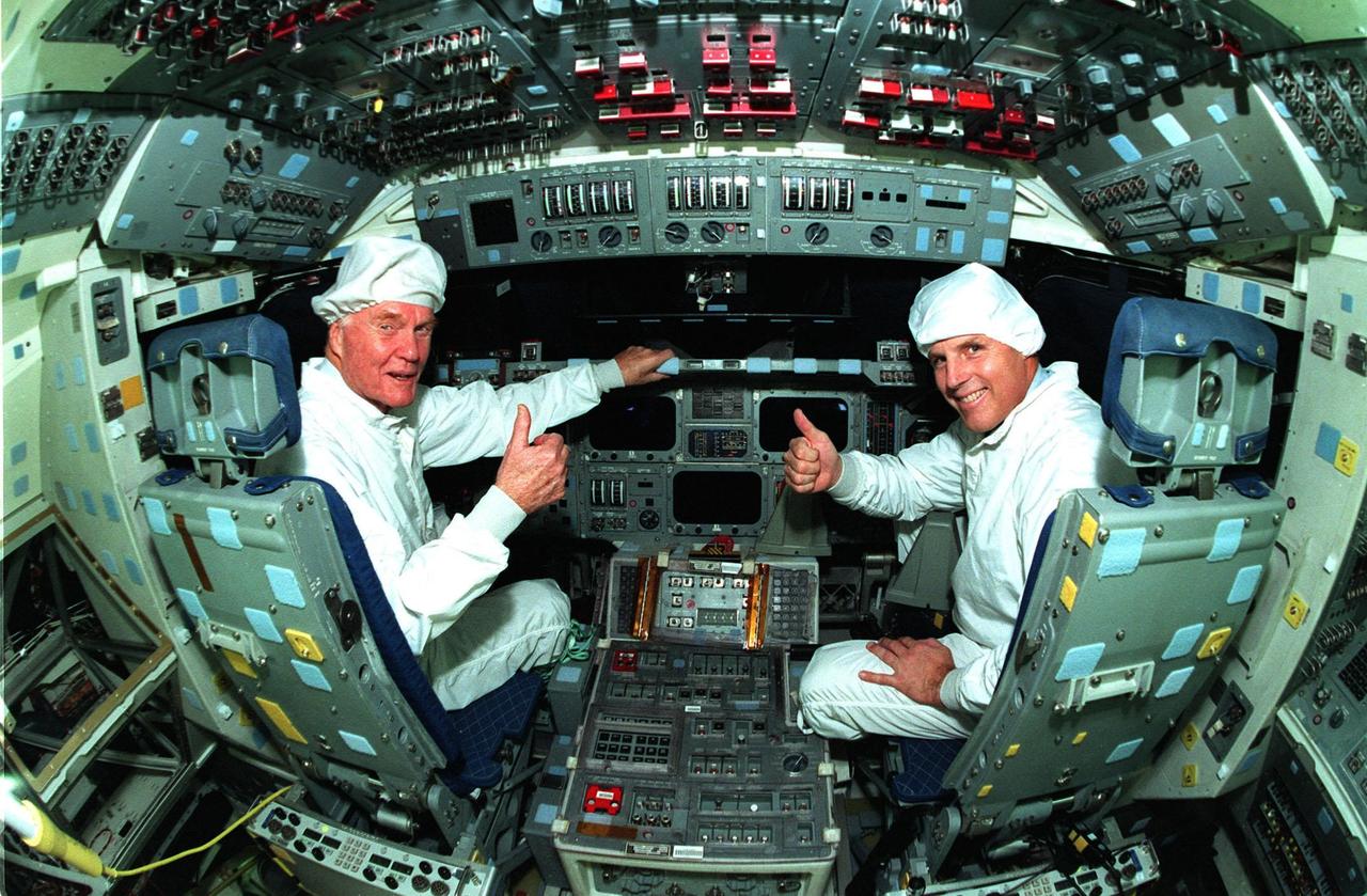 Ohio Senator John Glenn, at left, enjoys a tour of the flight deck in the orbiter Columbia with Astronaut Stephen Oswald at the Orbiter Processing Facility 3 at Kennedy Space Center. Senator Glenn arrived at KSC on Jan. 20 to tour KSC operational areas and to view the launch of STS-89 later this week. Glenn, who made history in 1962 as the first American to orbit the Earth, completing three orbits in a five-hour flight aboard Friendship 7, will fly his second space mission aboard Space Shuttle Discovery this October. Glenn is retiring from the Senate at the end of this year and will be a payload specialist aboard STS-95