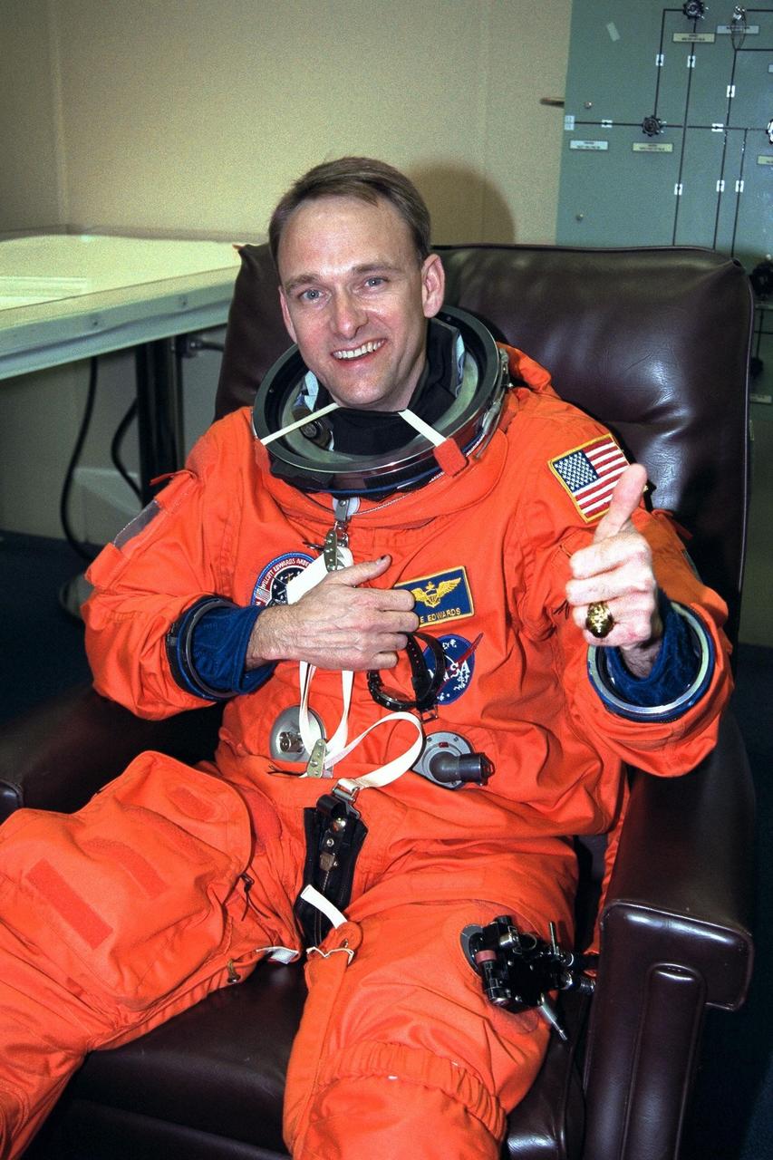 STS-89 Pilot Joe Edwards Jr. gives a ‘thumbs up’ as he completes the donning of his launch/entry suit in the Operations and Checkout (O&C) Building. He has flown more than 2,600 hours in over 25 different aircraft and logged over 650 arrested landings. He and six fellow crew members will soon depart the O&C and head for Launch Pad 39A, where the Space Shuttle Endeavour will lift off during a launch window that opens at 9:43 p.m. EST, Jan. 22. STS-89 is the eighth of nine planned missions to dock the Space Shuttle with Russia's Mir space station