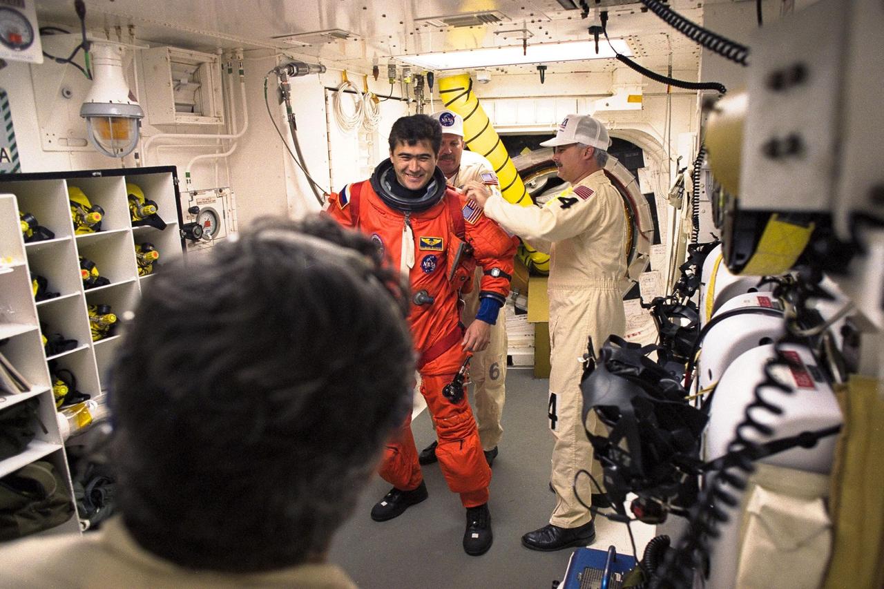 STS-89 Mission Specialist Salizhan Sharipov of the Russian Space Agency is assisted with his ascent and re-entry flight suit in the white room at Launch Pad 39A before entering Space Shuttle Endeavour for launch. The STS-89 mission will be the eighth docking of the Space Shuttle with the Russian Space Station Mir. After docking, Mission Specialist Andrew Thomas, Ph.D., will transfer to the space station, succeeding David Wolf, M.D., who will return to Earth aboard Endeavour. Dr. Thomas will live and work on Mir until June. STS-89 is scheduled for a Jan. 22 liftoff at 9:48 p.m