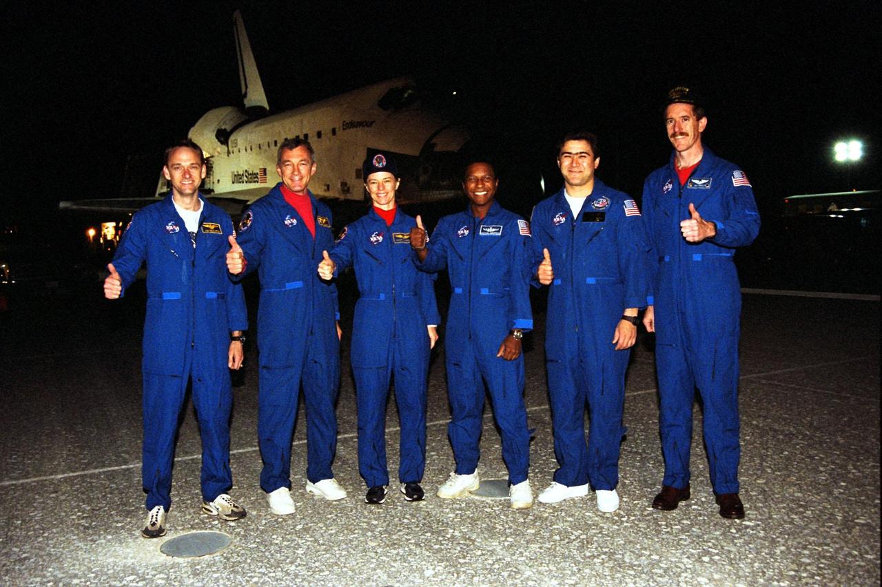 KENNEDY SPACE CENTER, FLA. -- STS-89 crew members give a "thumbs up" on KSC’s Runway 15 following completion of their successful mission that lasted nearly nine days. From left are Pilot Joe Edwards Jr.; Commander Terrence Wilcutt; and Mission Specialists Bonnie Dunbar, Ph.D.; Michael Anderson; Salizhan Sharipov of the Russian Space Agency; and James Reilly, Ph.D. Not shown are Mission Specialist Andrew Thomas, Ph.D., and returning astronaut and Mir 24 crew member David Wolf, M.D. STS-89 was the eighth docking of the Space Shuttle with the Russian Space Station Mir. Dr. Thomas succeeded Dr. Wolf on Mir, who has been on the Russian space station since late September. Dr. Thomas is scheduled to remain on Mir until the STS-91 Shuttle mission returns in June 1998. In addition to the docking and crew exchange, STS-89 included the transfer of science, logistical equipment and supplies between the two orbiting spacecrafts