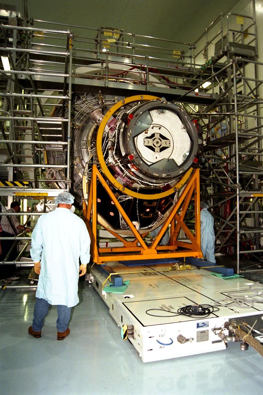 KENNEDY SPACE CENTER, FLA. -- The Pressurized Mating Adapter (PMA)-2, seen here in its yellow workstand, is moved on an air pallet toward Node 1, the International Space Station’s (ISS's) structural building block, in KSC’s Space Station Processing Facility. This PMA is a cone-shaped connector to Node 1, which will have two PMAs attached once PMA-2 is mated with the node. Node 1 can be seen directly behind PMA-2. The node and PMAs, which together will make up the first element of the ISS, are scheduled to be launched aboard the Space Shuttle Endeavour on STS-88.