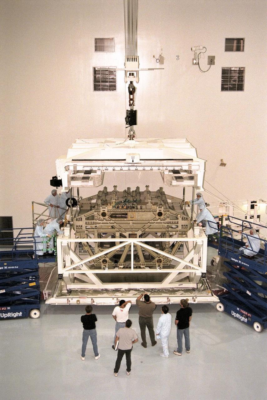 KENNEDY SPACE CENTER, FLA. -- The Z1 Integrated Truss Segment (ITS), a major element of the STS-92 mission scheduled for launch aboard Space Shuttle Atlantis in January 1999, is lowered into its workstand for processing in KSC's Space Station Processing Facility (SSPF). The Z-1 truss supports the staged buildup of International Space Station (ISS) on this third scheduled flight for ISS. The Z1 truss allows the temporary installation of the U.S. power module to Node 1. Early in the assembly sequence, the purpose of Z1 is to provide a mounting location for Ku-band and S-band telemetry and extravehicular activity (EVA) equipment. It also provides common berthing mechanism hardcover stowage. In addition, it will assist with the execution of nonpropulsive attitude control. The truss arrived at KSC on Feb. 17 for preflight processing in the SSPF
