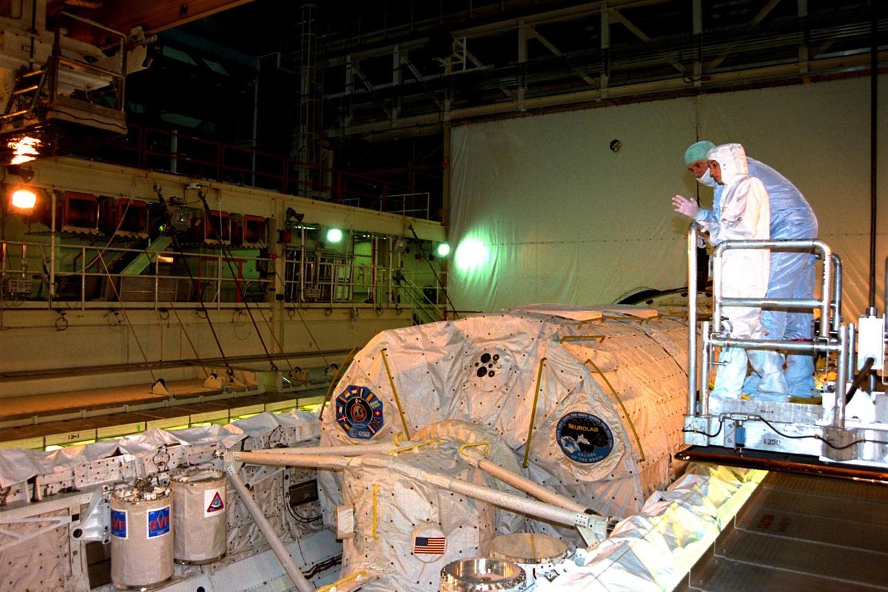 Stacie Greene, an extravehicular activity trainer from Johnson Space Center, discusses the STS-90 Neurolab mission with Mission Specialist Richard Linnehan overlooking Columbia's payload bay. The crew of STS-90 participated in the Crew Equipment Interface Test (CEIT) in Kennedy Space Center's Orbiter Processing Facility Bay 3. The CEIT gives astronauts an opportunity to get a hands-on look at the payloads with which they will be working on-orbit. Investigations during the STS-90 Neurolab mission will focus on the effects of microgravity on the nervous system. Specifically, experiments will study the adaptation of the vestibular system, the central nervous system, and the pathways that control the ability to sense location in the absence of gravity, as well as the effect of microgravity on a developing nervous system. STS-90 is scheduled for launch on April 16 at 2:19 p.m. EDT