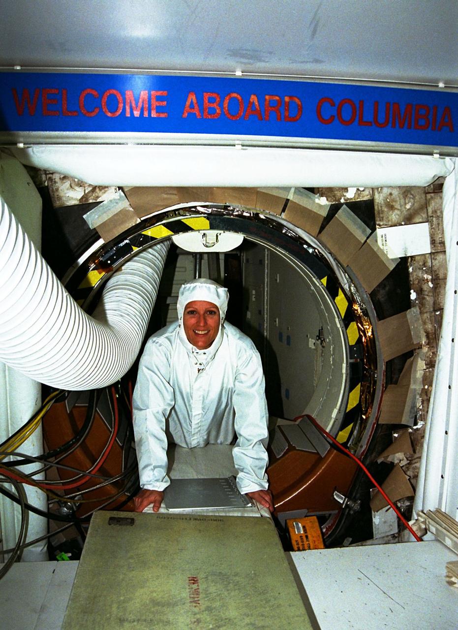 STS-90 Mission Specialist Kathryn (Kay) Hire enjoys the crawl between Columbia and the white room that allows access to the orbiter. The crew of STS-90 recently participated in the Crew Equipment Interface Test (CEIT) in Kennedy Space Center's Orbiter Processing Facility Bay 3. The CEIT gives astronauts an opportunity to get a hands-on look at the payloads with which they will be working on-orbit. Investigations during the STS-90 Neurolab mission will focus on the effects of microgravity on the nervous system. Specifically, experiments will study the adaptation of the vestibular system, the central nervous system, and the pathways that control the ability to sense location in the absence of gravity, as well as the effect of microgravity on a developing nervous system. STS-90, which will be Hire's first Shuttle flight, is scheduled for launch on April 16 at 2:19 p.m. EDT