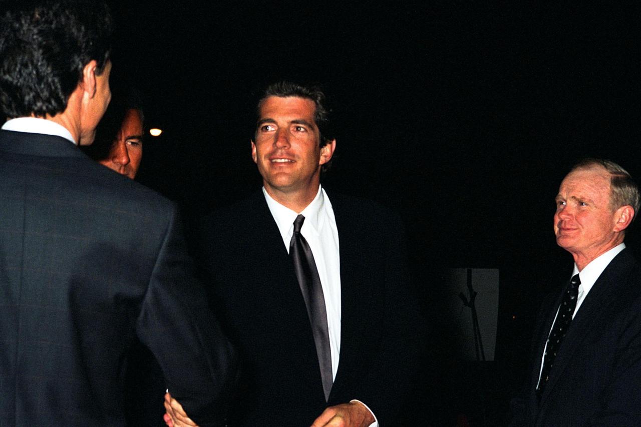 KENNEDY SPACE CENTER, FLA. -- John F. Kennedy Jr., editor-in-chief of George Magazine, greets invited guests at the Home Box Office (HBO) and Imagine Entertainment premiere of the 12-part miniseries "From the Earth to the Moon" at Kennedy Space Center (KSC). The series was filmed in part on location at KSC and dramatizes the human aspects of NASA's efforts to launch Americans to the Moon. The miniseries highlights NASA's Apollo program and the events leading up to and including the six successful missions to the Moon. A special 500-seat theater was constructed next to the Apollo/Saturn V Center for the KSC premiere showing. Speakers at the event included KSC Director Roy Bridges (at right); Jeff Bewkes, chairman and CEO for HBO; and John F. Kennedy Jr. Also attending the event, which featured the episode entitled "1968," were Buzz Aldrin, Apollo 11 astronaut, and Al Worden, Apollo 15 astronaut. The original miniseries event, created for HBO by actor Tom Hanks and Imagine Entertainment, will premiere on HBO beginning April 5, 1998