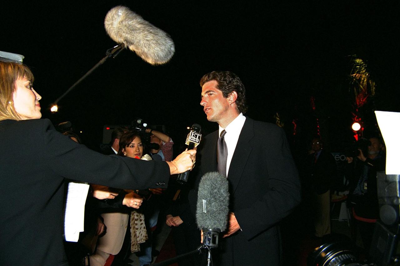 KENNEDY SPACE CENTER, FLA. -- John F. Kennedy Jr., editor-in-chief of George Magazine, speaks with members of the national media at the Home Box Office (HBO) and Imagine Entertainment premiere of the 12-part miniseries "From the Earth to the Moon" at Kennedy Space Center (KSC). The series was filmed in part on location at KSC and dramatizes the human aspects of NASA's efforts to launch Americans to the Moon. The miniseries highlights NASA's Apollo program and the events leading up to and including the six successful missions to the Moon. A special 500-seat theater was constructed next to the Apollo/Saturn V Center for the KSC premiere showing. Speakers at the event included KSC Director Roy Bridges (at right); Jeff Bewkes, chairman and CEO for HBO; and John F. Kennedy Jr. Also attending the event, which featured the episode entitled "1968," were Buzz Aldrin, Apollo 11 astronaut, and Al Worden, Apollo 15 astronaut. The original miniseries event, created for HBO by actor Tom Hanks and Imagine Entertainment, will premiere on HBO beginning April 5, 1998