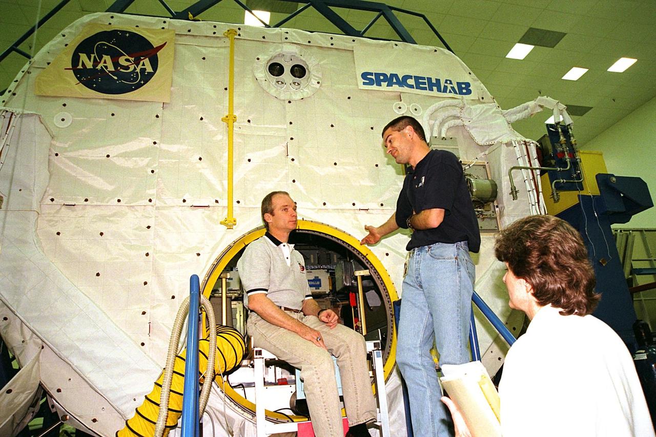 KENNEDY SPACE CENTER, FLA. -- The STS-91 crew participate in the Crew Equipment Interface Test (CEIT) for their upcoming Space Shuttle mission at the SPACEHAB Payload Processing Facility in Cape Canaveral. The CEIT gives astronauts an opportunity to get a hands-on look at the payloads with which they will be working on-orbit. STS-91 will be the ninth and final scheduled Mir docking and will include a single module of SPACEHAB, used mainly as a large pressurized cargo container for science, logistical equipment and supplies to be exchanged between the orbiter Discovery and the Russian Space Station Mir. The nearly 10-day flight of STS-91 also is scheduled to include the return of the last astronaut to live and work aboard the Russian orbiting outpost, Mission Specialist Andy Thomas, Ph.D. Liftoff of Discovery and its six-member crew is targeted for May 28, 1998, at 8:05 p.m. EDT from Launch Pad 39A. Sitting in front of SPACEHAB is STS-91 Commander Charles Precourt listening to instruction by Chris Jaskolka, Boeing SPACEHAB Program senior engineer, as Lynn Ashby, Boeing SPACEHAB Program principal engineer, looks on