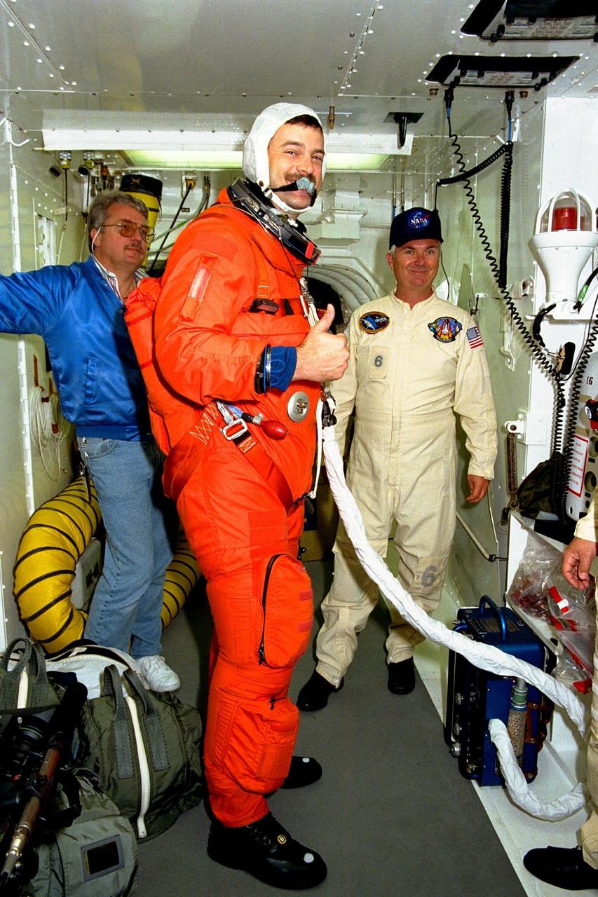 The crew of STS-90 participate in Terminal Countdown Demonstration Test (TCDT) activities at KSC's Launch Pad 39B. The TCDT is held at KSC prior to each Space Shuttle flight to provide crews with the opportunity to participate in simulated countdown activities. Here, STS-90 Pilot Scott Altman gives a "thumbs-up" after being suited up in his orange launch and re-entry suit. Columbia is targeted for launch of STS-90 on April 16 at 2:19 p.m. EDT and will be the second mission of 1998. The mission is scheduled to last nearly 17 days