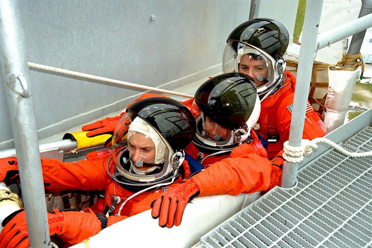 Members of the STS-90 crew participate in mock emergency egress activities during the Terminal Countdown Demonstration Test (TCDT) at KSC's Launch Pad 39B. The TCDT is held at KSC prior to each Space Shuttle flight to provide crews with the opportunity to participate in simulated countdown activities. The STS-90 crew members shown here are, front to back, Payload Specialists James Pawelczyk, Ph.D., and Jay Buckey, M.D., and Mission Specialist Richard Linnehan, D.V.M. Columbia is targeted for launch of STS-90 on April 16 at 2:19 p.m. EDT and will be the second mission of 1998. The mission is scheduled to last nearly 17 days
