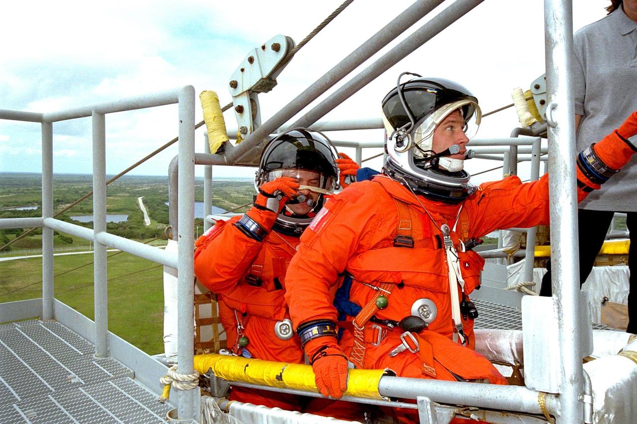 Members of the STS-90 crew participate in mock emergency egress activities during the Terminal Countdown Demonstration Test (TCDT) at KSC's Launch Pad 39B. The TCDT is held at KSC prior to each Space Shuttle flight to provide crews with the opportunity to participate in simulated countdown activities. The STS-90 crew members shown here are Commander Richard Searfoss (front) and Pilot Scott Altman. Columbia is targeted for launch of STS-90 on April 16 at 2:19 p.m. EDT and will be the second mission of 1998. The mission is scheduled to last nearly 17 days