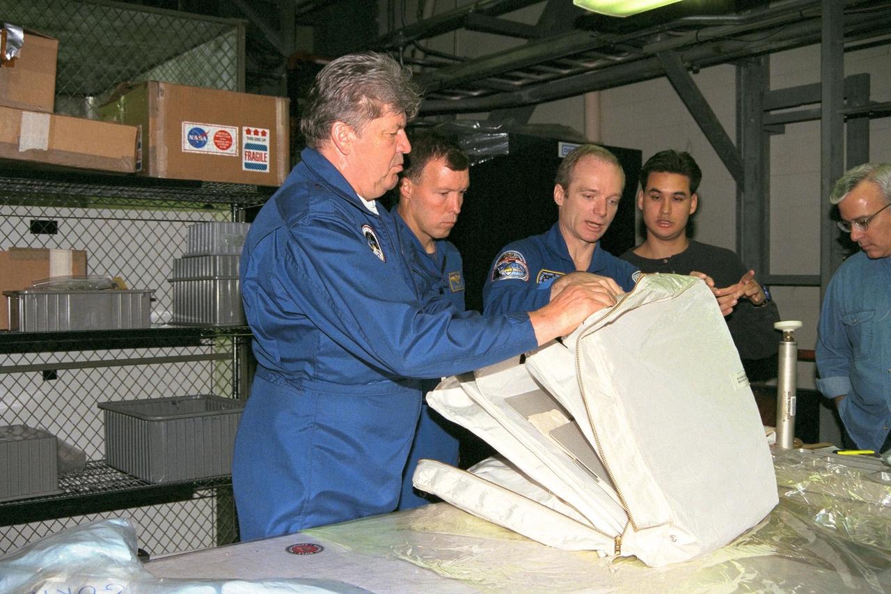 STS-91 Mission Specialist Valery Ryumin with the Russian Space Agency, Pilot Dominic Gorie, Commander Charles Precourt, and Adam Flagan, a crew equipment trainer from Johnson Space Center, inspect a flight pack as part of Crew Equipment Interface Test, or CEIT, activities in KSC's Orbiter Processing Facility Bay 2. During CEIT, the crew have an opportunity to get a hands-on look at the payloads with which they'll be working on-orbit. The STS-91 crew are scheduled to launch aboard the Shuttle Discovery for the ninth and final docking with the Russian Space Station Mir from KSC's Launch Pad 39A on May 28 at 8:05 EDT