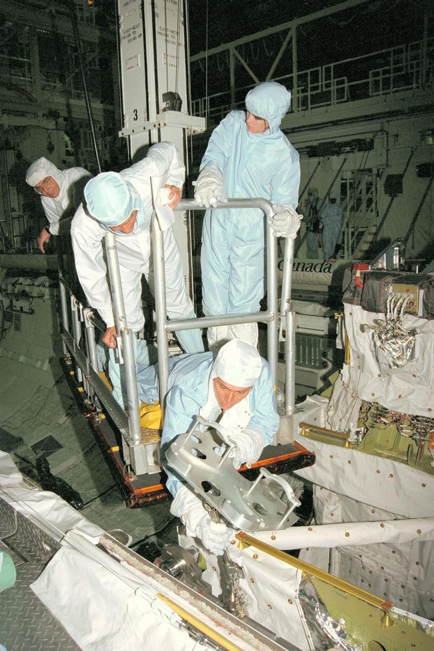 STS-91 crew members participate in the Crew Equipment Interface Test, or CEIT, in KSC's Orbiter Processing Facility Bay 2. Laying down inspecting a foot restraint for an extravehicular activity (EVA) spacewalk is STS-91 Mission Specialist Franklin Chang-Diaz, Ph.D. Looking over his shoulder is Kieth Johnson, an EVA trainer and flight controller from Johnson Space Center. STS-91 Mission Specialist Janet Kavandi, Ph.D., stands next to Johnson. During CEIT, the crew have an opportunity to get a hands-on look at the payloads with which they'll be working on-orbit. The STS-91 crew are scheduled to launch aboard the Shuttle Discovery for the ninth and final docking with the Russian Space Station Mir from KSC's Launch Pad 39A on May 28 at 8:05 EDT