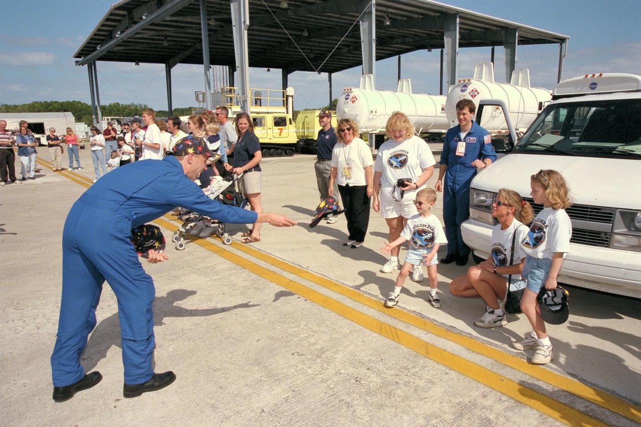 KENNEDY SPACE CENTER, FLA. -- STS-90 Payload Specialist James Pawelczyk, Ph.D., tosses mission hats to his two children shortly after arrival at Kennedy Space Center's Shuttle Landing Facility. The crew of STS-90 arrived at KSC in preparation for their mission, scheduled for launch from KSC's Launch Pad 39B on April 16 at 2:19 p.m. EDT. The flight of Neurolab is scheduled to last nearly 17 days.