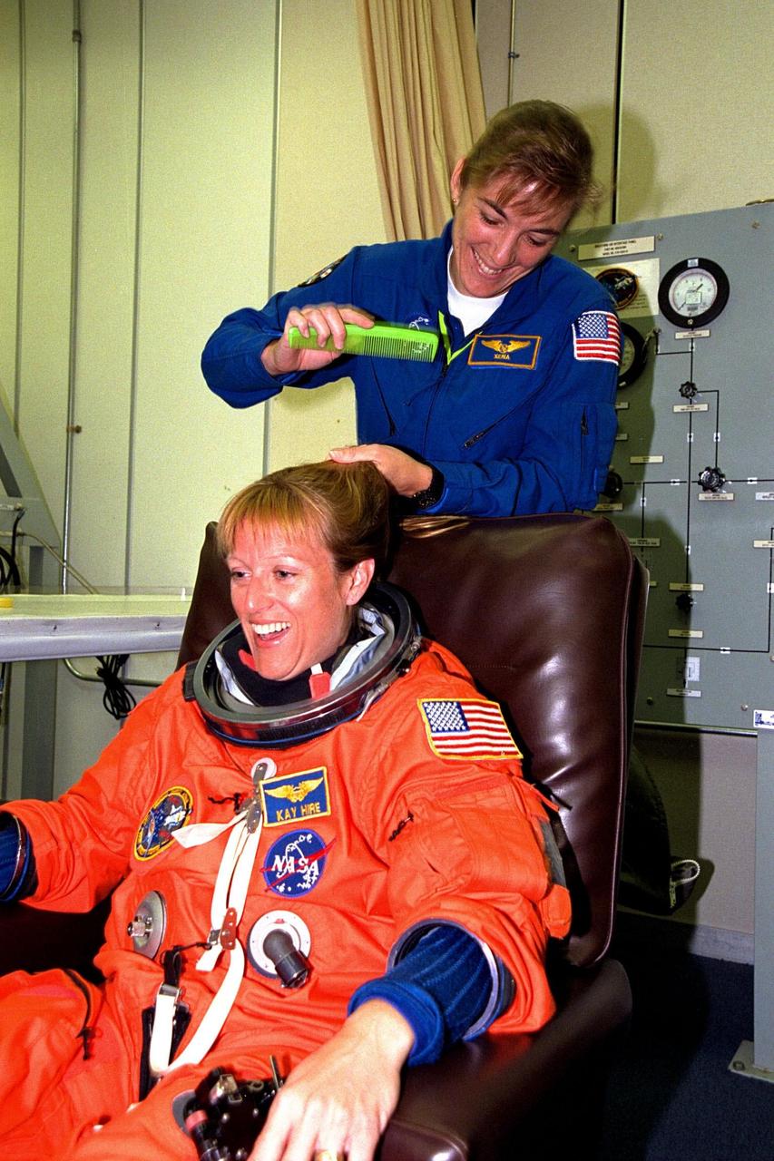 KENNEDY SPACE CENTER, FLA. -- STS-90 Mission Specialist Kathryn (Kay) Hire prepares for launch during suitup activities in the Operations and Checkout Building as Astronaut Support Personnel team member Heide Piper braids Hire's hair. Hire and the rest of the STS-90 crew will shortly depart for Launch Pad 39B, where the Space Shuttle Columbia awaits a second liftoff attempt at 2:19 p.m. EDT. Her first trip into space, Hire is participating in this life sciences research flight that will focus on the most complex and least understood part of the human body the nervous system. Neurolab will examine the effects of spaceflight on the brain, spinal cord, peripheral nerves and sensory organs in the human body.