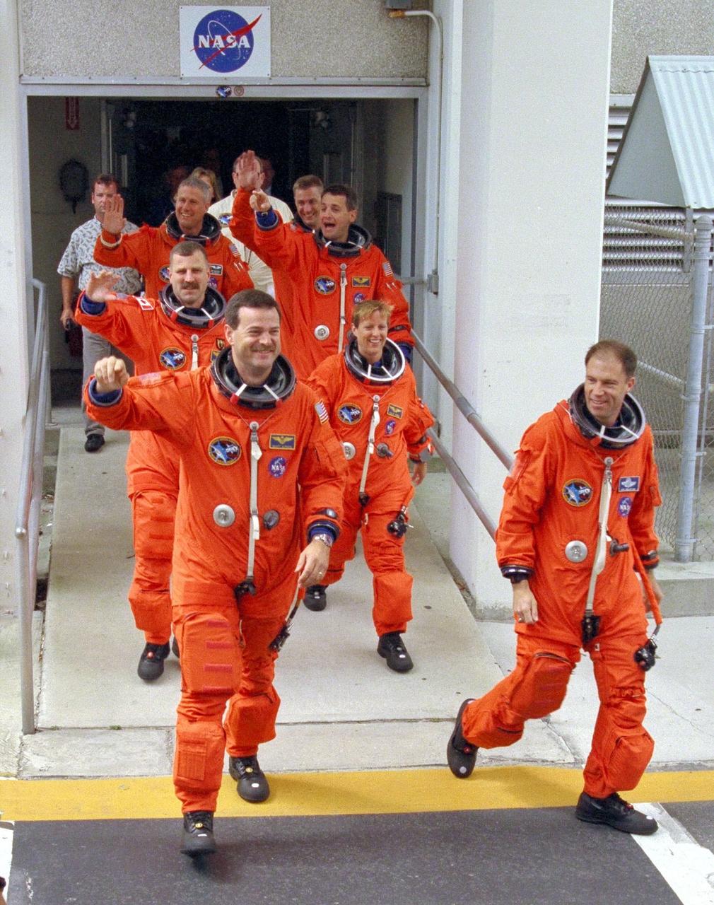 KENNEDY SPACE CENTER, FLA. -- Greeted by cheers from wellwishers at KSC and eager for their venture into space on the Neurolab mission, the STS-90 astronauts depart the Operations and Checkout Building on their way to Launch Pad 39B. Leading the seven-member crew is Mission Commander Richard Searfoss (far right), with Pilot Scott Altman by his side. Behind Altman are Mission Specialist Dafydd (Dave) Williams, M.D., (waving) with the Canadian Space Agency, and Mission Specialist Kathryn (Kay) Hire. Behind Hire is Mission Specialist Richard Linnehan, D.V.M., and next to Linnehan is Payload Specialist Jay Buckey, M.D. At the rear behind Linnehan is Payload Specialist James Pawelczyk, Ph.D. Their trip to the pad will take about 25 minutes aboard the Astrovan. Once there, they will take their positions in the crew cabin of the Space Shuttle Columbia to await a liftoff during a two-and-a-half hour window that will open at 2:19 p.m. EDT