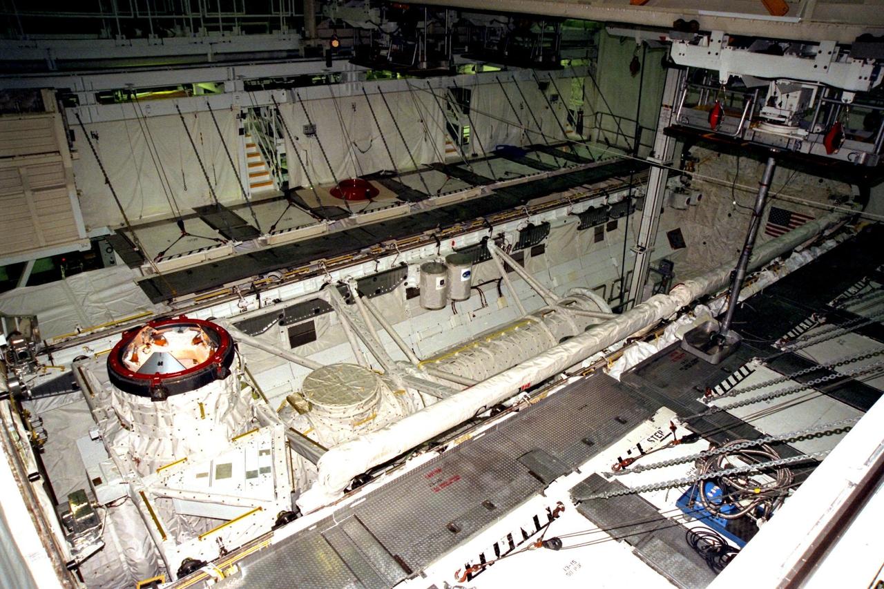 Processing activities for STS-91 continue in KSC's Orbiter Processing Facility Bay 2. The payload bay of Space Shuttle Discovery is relatively empty as installation of the Get Away Special (GAS) canisters begins. Two GAS canisters can be seen in the center of the photograph. On the left is G-648, a Canadian Space Agency-sponsored study on manufactured organic thin film by the physical vapor transport method, and on the right is a can with hundreds of commemorative flags to be flown on the mission. STS-91 is scheduled to launch aboard the Space Shuttle Discovery for the ninth and final docking with the Russian Space Station Mir from KSC's Launch Pad 39A on June 2 with a launch window opening around 6:04 p.m. EDT
