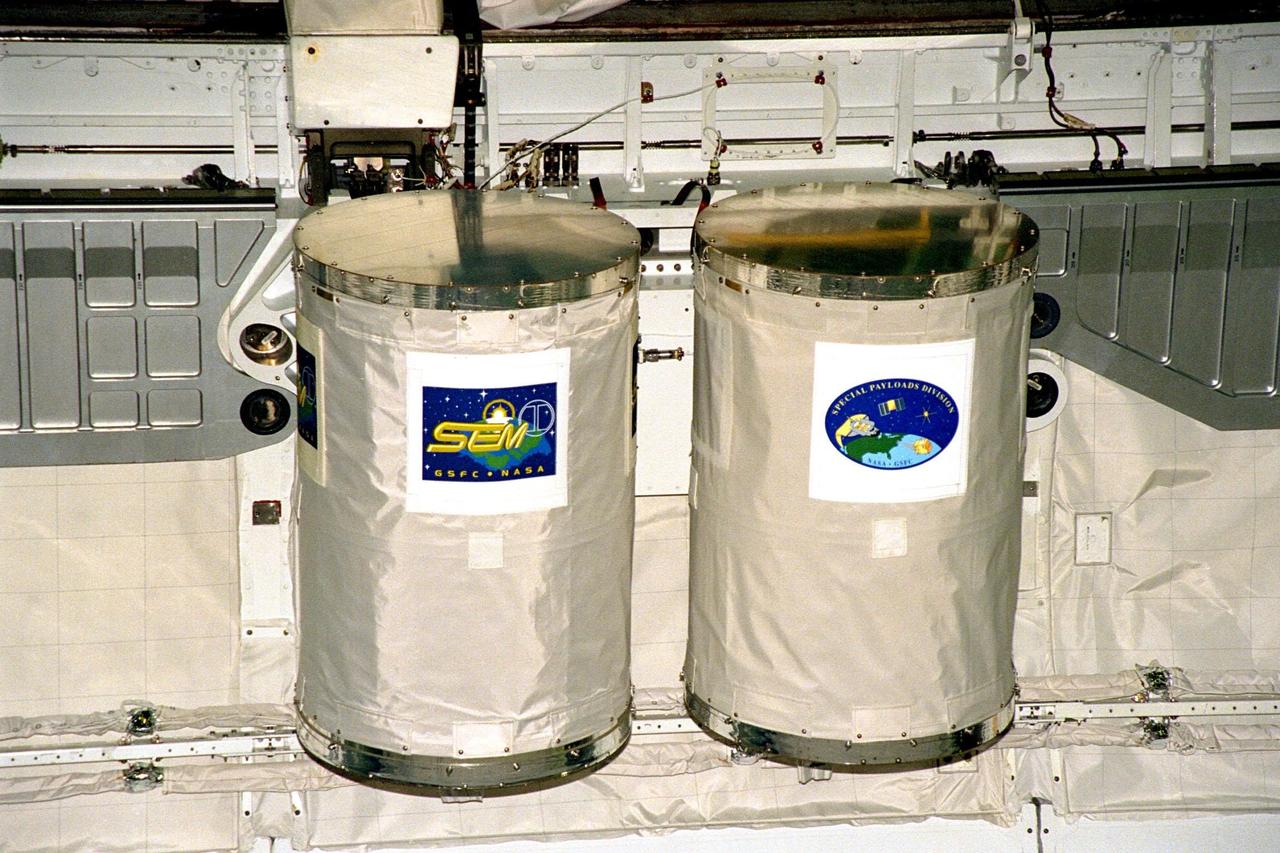 Processing activities for STS-91 continue in KSC's Orbiter Processing Facility Bay 2. Two Get Away Special (GAS) canisters are shown after their installation into Discovery's payload bay. The GAS canister on the left houses the Space Experiment Module (SEM-03), part of an educational initiative of NASA's Shuttle Small Payloads Project. On the right is a canister containing commemorative flags to be flown during the mission. STS-91 is scheduled to launch aboard the Space Shuttle Discovery for the ninth and final docking with the Russian Space Station Mir from KSC's Launch Pad 39A on June 2 with a launch window opening around 6:04 p.m. EDT