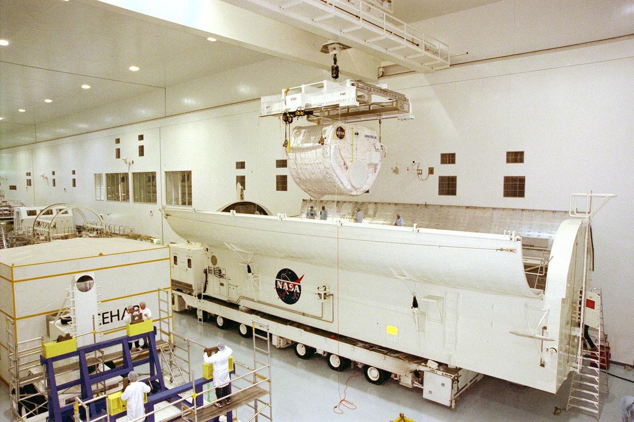 KENNEDY SPACE CENTER, FLA. -- The SPACEHAB Single Module is moved by crane over the payload canister in KSC's Space Station Processing Facility. It will be joined in the canister by the Alpha Magnetic Spectrometer-01 payload before being moved to Launch Pad 39A for the STS-91 mission, scheduled to launch June 2 at around 6:04 p.m. EDT. SPACEHAB is used mainly as a large pressurized cargo container for science, logistical equipment and supplies to be exchanged between the orbiter Discovery and the Russian Space Station Mir. The nearly 10-day flight of STS-91 also is scheduled to return the sixth American, Mission Specialist Andrew Thomas, Ph.D., aboard the Russian orbiting outpost safely to Earth