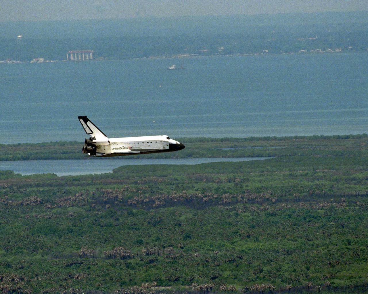 Flying along the Indian River toward KSC's Shuttle Landing Facility is the orbiter Columbia as it nears touchdown on Runway 33 to complete the nearly 16-day STS-90 mission. This unique view with Titusville and the Indian River in the background was taken from the roof of the 525-foot-high Vehicle Assembly Building. Main gear touchdown was at 12:08:59 p.m. EDT on May 3, 1998, landing on orbit 256 of the mission. The wheels stopped at 12:09:58 EDT, completing a total mission time of 15 days, 21 hours, 50 minutes and 58 seconds. The 90th Shuttle mission was Columbia's 13th landing at the space center and the 43rd KSC landing in the history of the Space Shuttle program. During the mission, the crew conducted research to contribute to a better understanding of the human nervous system. The crew of the STS-90 Neurolab mission include Commander Richard Searfoss; Pilot Scott Altman; Mission Specialists Richard Linnehan, D.V.M., Dafydd (Dave) Williams, M.D., with the Canadian Space Agency, and Kathryn (Kay) Hire; and Payload Specialists Jay Buckey, M.D., and James Pawelczyk, Ph.D