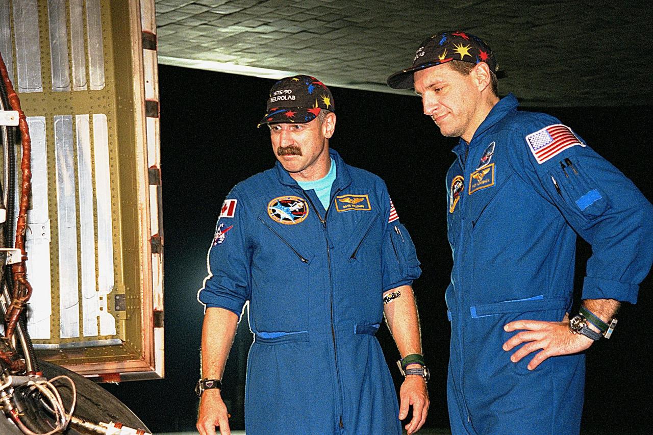 STS-90 Mission Specialists Dafydd (Dave) Williams, M.D., with the Canadian Space Agency (left) and Richard Linnehan, D.V.M., inspect the orbiter Columbia's tires in the evening after their midday arrival on May 3, ending their nearly 16-day Neurolab mission. The 90th Shuttle mission was Columbia's 13th landing at the space center and the 43rd KSC landing in the history of the Space Shuttle program. During the mission, the crew conducted research to contribute to a better understanding of the human nervous system