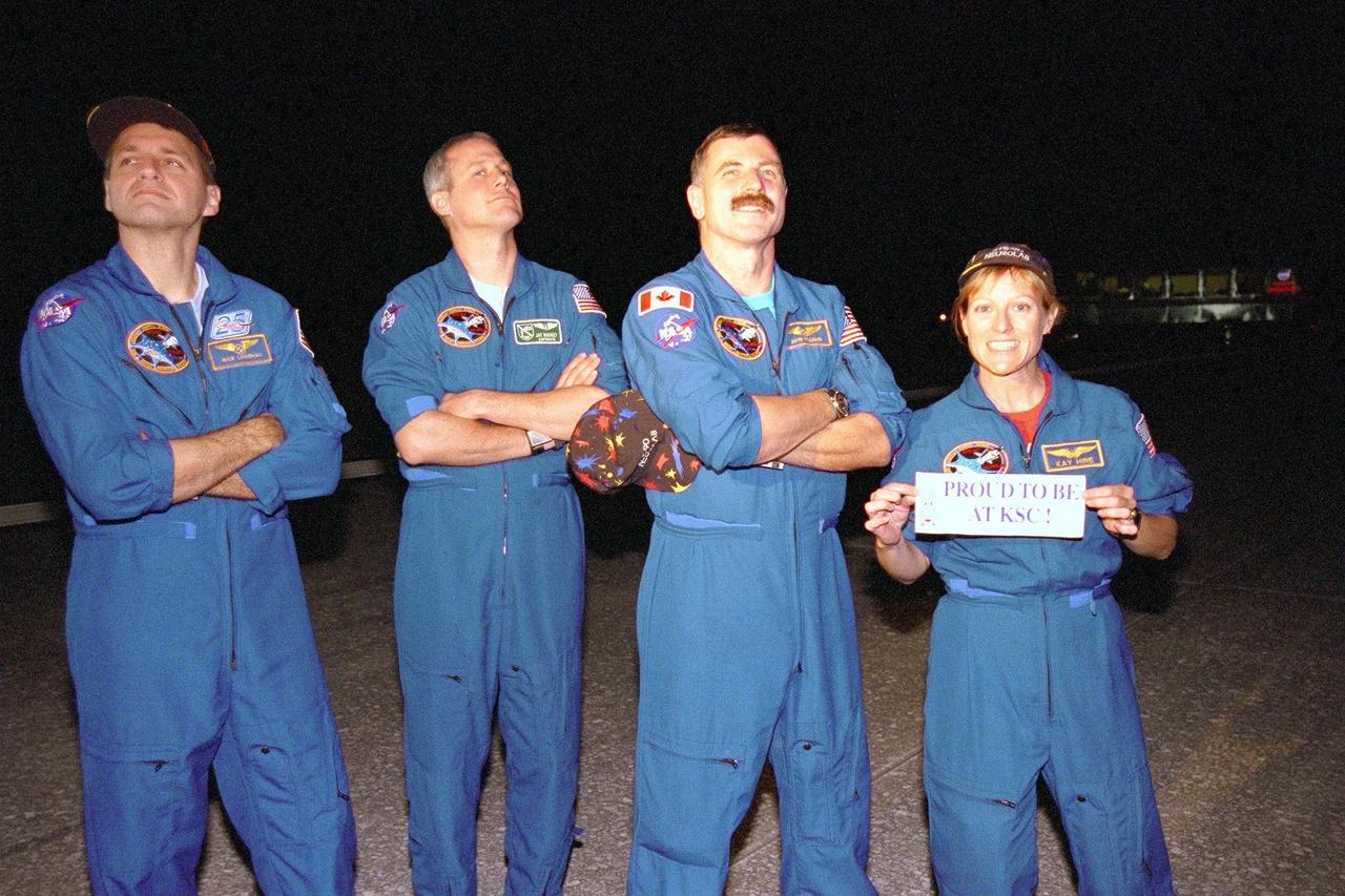Some of the STS-90 crew members pose at the Shuttle Landing Facility hours after arrival on May 3, ending their nearly 16-day Neurolab mission. Shown left to right are Mission Specialist Richard Linnehan, D.V.M.; Payload Specialist Jay Buckey, M.D.; and Mission Specialists Dafydd (Dave) Williams, M.D., with the Canadian Space Agency and Kathryn (Kay) Hire holding a sign that states "Proud to be at KSC." The 90th Shuttle mission was Columbia's 13th landing at the space center and the 43rd KSC landing in the history of the Space Shuttle program. During the mission, the crew conducted research to contribute to a better understanding of the human nervous system