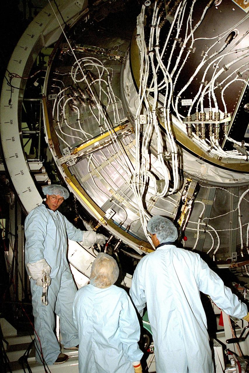Boeing technicians discuss mating Pressurized Mating Adapter (PMA)-2 to Node 1 of the International Space Station (ISS) in KSC's Space Station Processing Facility (SSPF). The node is the first element of the ISS to be manufactured in the United States and is currently scheduled to lift off aboard the Space Shuttle Endeavour on STS-88 later this year, along with PMAs 1 and 2. This PMA is a cone-shaped connector to Node 1, which will have two PMAs attached once this mate is completed. Once in space, Node 1 will function as a connecting passageway to the living and working areas of the ISS. It has six hatches that will serve as docking ports to the U.S. laboratory module, U.S. habitation module, an airlock and other space station elements