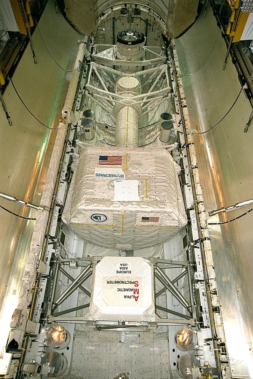 A SPACEHAB Single Module (top) and the Alpha Magnetic Spectrometer (AMS) experiment are secure in Discovery's payload bay shortly before the payload bay doors are closed for the flight of STS-91 at Launch Pad 39A. Launch is planned for June 2 with a window opening around 6:10 p.m. EDT. The single SPACEHAB module houses experiments to be performed by the astronauts and serves as a cargo carrier for items to be transferred to and from the Russian Space Station Mir. The AMS experiment is the first of a new generation of space-based experiments which will use particles, instead of light, to study the Universe and will search for both antimatter and "dark matter," as well as measure normal matter cosmic and gamma rays. STS-91 will also feature the ninth Shuttle docking with the Russian Space Station Mir, the first Mir docking for Discovery, the conclusion of Phase I of the joint U.S.-Russian International Space Station Program, and the first flight of the new Space Shuttle super lightweight external tank. The STS-91 flight crew includes Commander Charles Precourt; Pilot Dominic Gorie; and Mission Specialists Wendy B. Lawrence; Franklin Chang-Diaz, Ph.D.; Janet Kavandi, Ph.D.; and Valery Ryumin, with the Russian Space Agency. Andrew Thomas, Ph.D., will be returning to Earth with the crew after living more than four months aboard Mir
