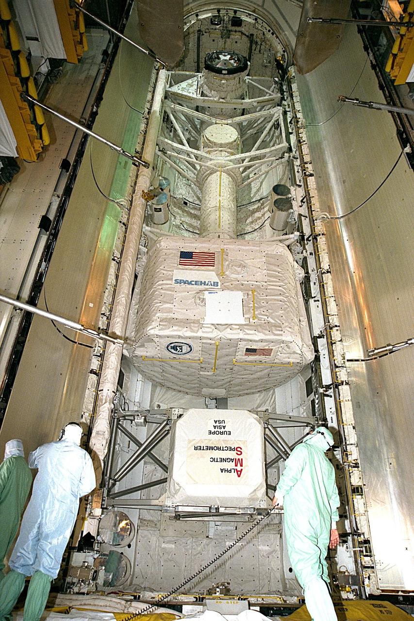 Technicians supervise the closure of Discovery's payload bay doors from the Payload Changout Room at Launch Pad 39A as preparations for the STS-91 launch continue. STS-91 is scheduled to be launched on June 2 with a launch window opening around 6:10 p.m. EDT. The mission will feature the ninth Shuttle docking with the Russian Space Station Mir, the first Mir docking for Discovery, the conclusion of Phase I of the joint U.S.-Russian International Space Station Program, and the first flight of the new Space Shuttle super lightweight external tank. The STS-91 flight crew includes Commander Charles Precourt; Pilot Dominic Gorie; and Mission Specialists Wendy B. Lawrence; Franklin Chang-Diaz, Ph.D.; Janet Kavandi, Ph.D.; and Valery Ryumin, with the Russian Space Agency. Andrew Thomas, Ph.D., will be returning to Earth with the crew after living more than four months aboard Mir