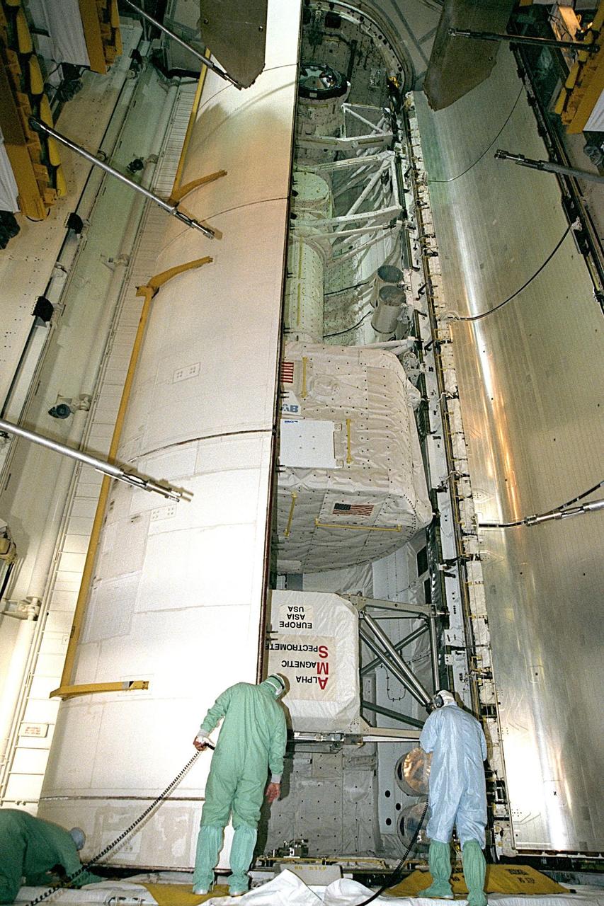 Technicians supervise the closure of Discovery's payload bay doors from the Payload Changout Room at Launch Pad 39A as preparations for the STS-91 launch continue. STS-91 is scheduled to be launched on June 2 with a launch window opening around 6:10 p.m. EDT. The mission will feature the ninth Shuttle docking with the Russian Space Station Mir, the first Mir docking for Discovery, the conclusion of Phase I of the joint U.S.-Russian International Space Station Program, and the first flight of the new Space Shuttle super lightweight external tank. The STS-91 flight crew includes Commander Charles Precourt; Pilot Dominic Gorie; and Mission Specialists Wendy B. Lawrence; Franklin Chang-Diaz, Ph.D.; Janet Kavandi, Ph.D.; and Valery Ryumin, with the Russian Space Agency. Andrew Thomas, Ph.D., will be returning to Earth with the crew after living more than four months aboard Mir