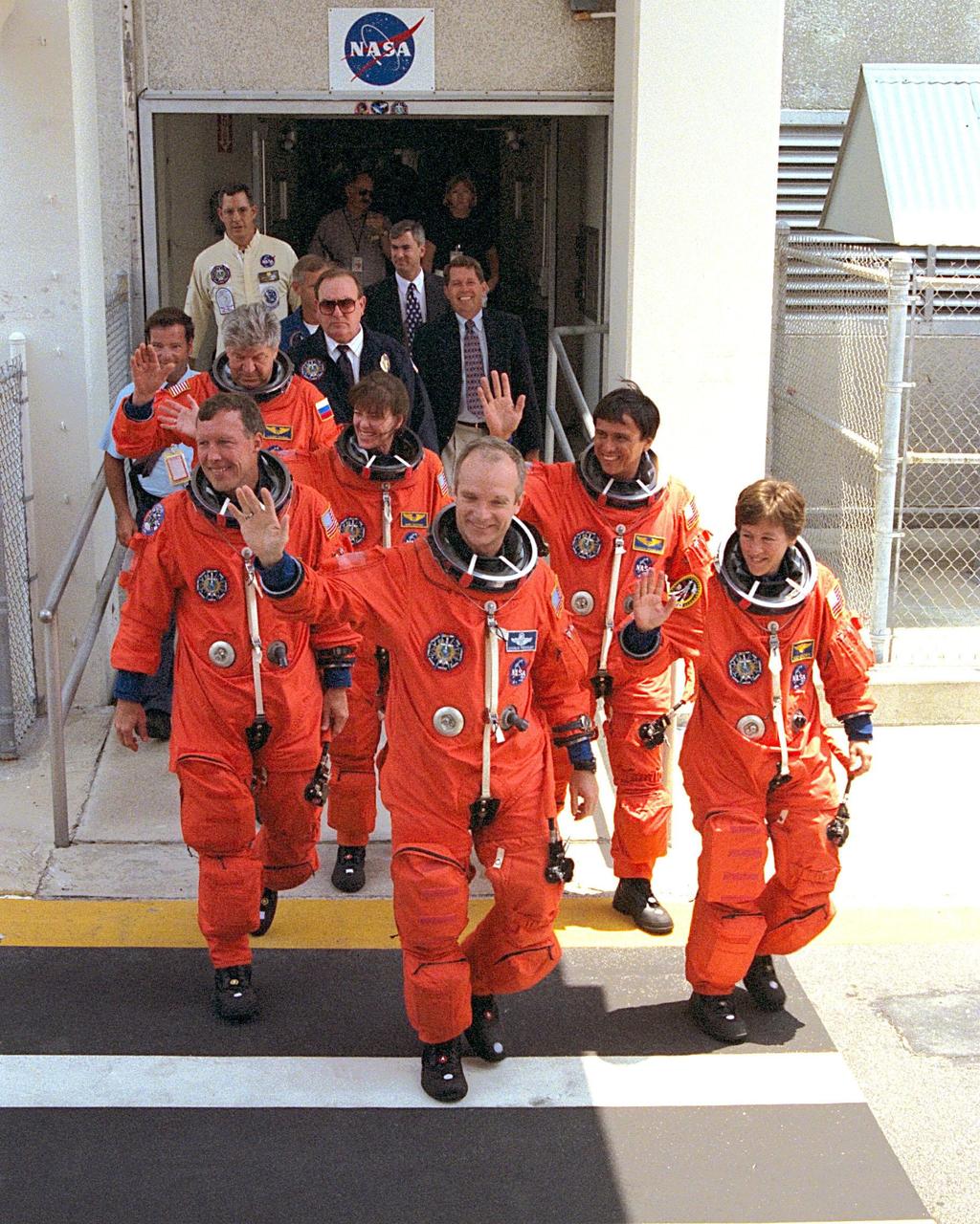 With an enthusiastic crowd of KSC workers wishing them a safe journey, the STS-91 crew walks out from the crew quarters in the Operations and Checkout (O&C) Building for their trip to Launch Pad 39A. Leading the group to the Astrovan are Mission Commander Charles J. Precourt (left) and Mission Specialist Wendy B. Lawrence. Pilot Dominic L. Gorie is directly behind Precourt, while Mission Specialists Franklin R. Chang-Diaz, Janet Lynn Kavandi and Valery Victorovitch Ryumin are behind Lawrence. STS-91 is scheduled to be launched on June 2 with a launch window opening around 6:10 p.m. EDT. The mission will feature the ninth and final Shuttle docking with the Russian space station Mir, the first Mir docking for Discovery, the first on-orbit test of the Alpha Magnetic Spectrometer (AMS), and the first flight of the new Space Shuttle super lightweight external tank. Astronaut Andrew S. W. Thomas will be returning to Earth as a STS-91 crew member after living more than four months aboard Mir