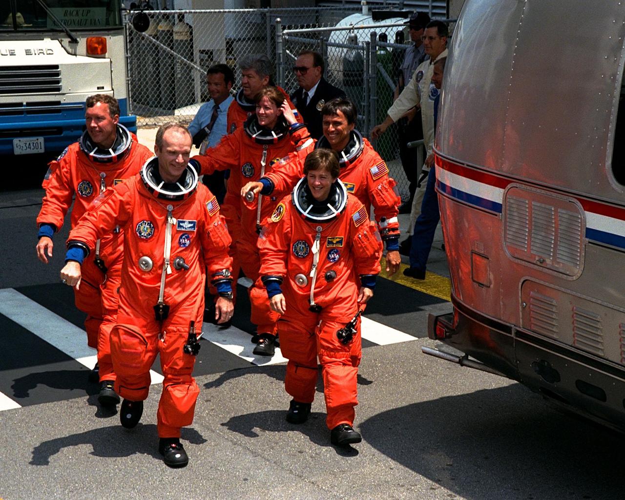 With an enthusiastic crowd of KSC workers wishing them a safe journey, the STS-91 crew walks out from the crew quarters in the Operations and Checkout (O&C) Building for their trip to Launch Pad 39A. Leading the group to the Astrovan are Mission Commander Charles J. Precourt (left) and Mission Specialist Wendy B. Lawrence. Pilot Dominic L. Gorie is directly behind Precourt, while Mission Specialists Franklin R. Chang-Diaz, Janet Lynn Kavandi and Valery Victorovitch Ryumin are behind Lawrence. STS-91 is scheduled to be launched on June 2 with a launch window opening around 6:10 p.m. EDT. The mission will feature the ninth and final Shuttle docking with the Russian space station Mir, the first Mir docking for Discovery, the first on-orbit test of the Alpha Magnetic Spectrometer (AMS), and the first flight of the new Space Shuttle super lightweight external tank. Astronaut Andrew S. W. Thomas will be returning to Earth as a STS-91 crew member after living more than four months aboard Mir