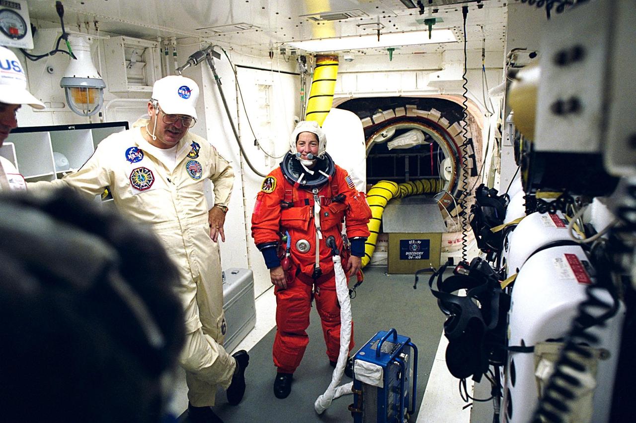 STS-91 Mission Specialist Wendy B. Lawrence is assisted with her preparations to enter the crew cabin of the Space Shuttle Discovery at Launch Pad 39A by white room crew member Greg Lohning