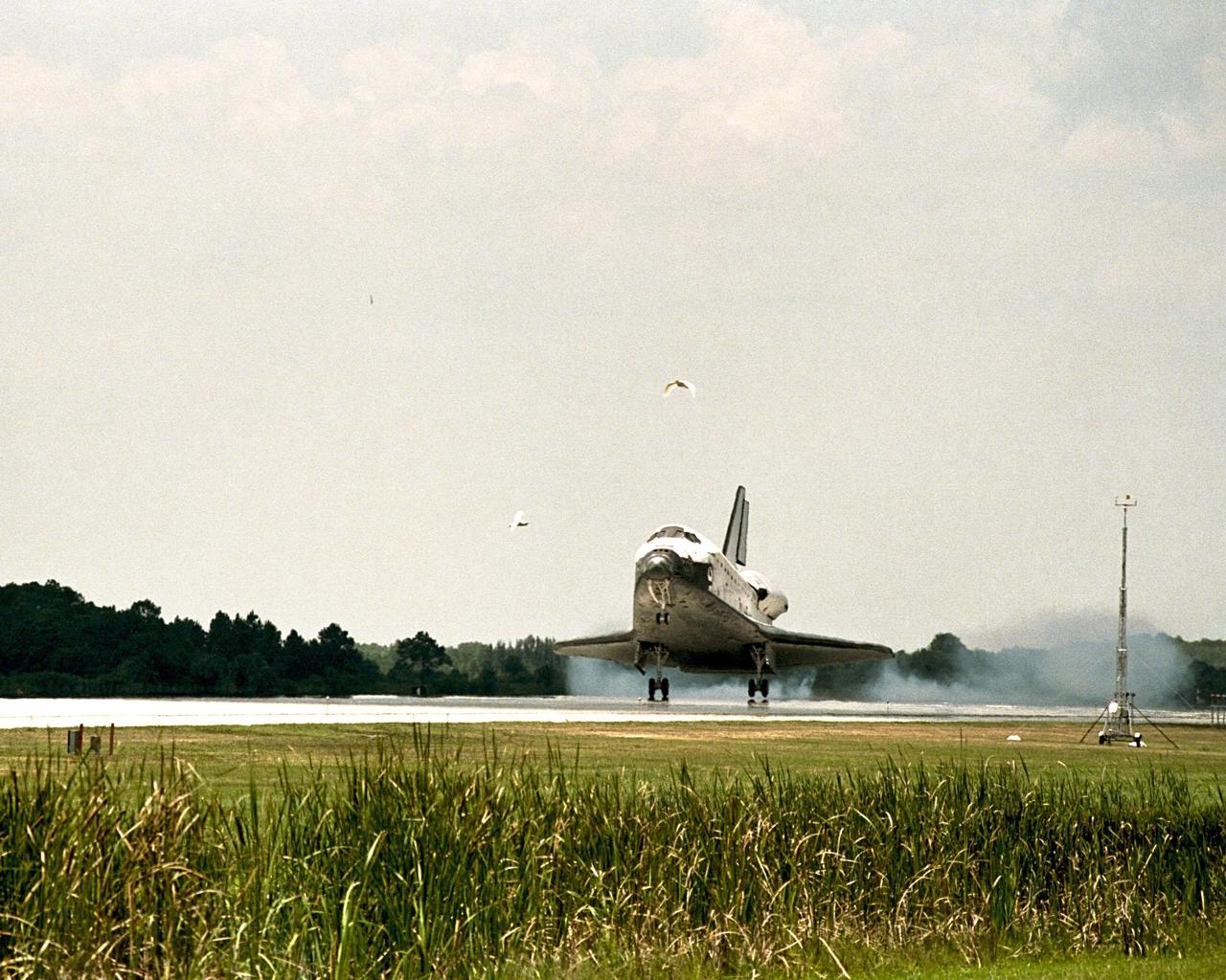 KENNEDY SPACE CENTER, FLA. -- Startled by the almost silent appearance of the orbiter Discovery as it lands following the STS-91 mission, several birds hurriedly leave KSC's Shuttle Landing Facility (SLF) for a more secluded spot. The SLF is nestled among the wilds of the Merritt Island National Wildlife Refuge, home to over 300 species of birds. Discovery's main gear touchdown on Runway 15 was at 2:00:18 p.m. EDT on June 12, 1998, landing on orbit 155 of the mission. The wheels stopped at 2:01:22 p.m. EDT, for a total mission-elapsed time of 9 days, 19 hours, 55 minutes and 1 second. The 91st Shuttle mission was the 44th KSC landing in the history of the Space Shuttle program and the 15th consecutive landing at KSC. During the mission, the orbiter docked with the Russian space station Mir for the ninth time, concluding Phase I of the joint U.S.-Russian International Space Station Program. STS-91 also featured first flights for both the Alpha Magnetic Spectrometer and the Space Shuttle super lightweight external tank. The STS-91 flight crew included Mission Commander Charles J. Precourt; Pilot Dominic L. Gorie; and Mission Specialists Wendy B. Lawrence, Franklin R. Chang-Diaz, Janet Lynn Kavandi and Valery Victorovitch Ryumin of the Russian Space Agency. Astronaut Andrew S. W. Thomas also returned to Earth as an STS-91 crew member after 141 days in space