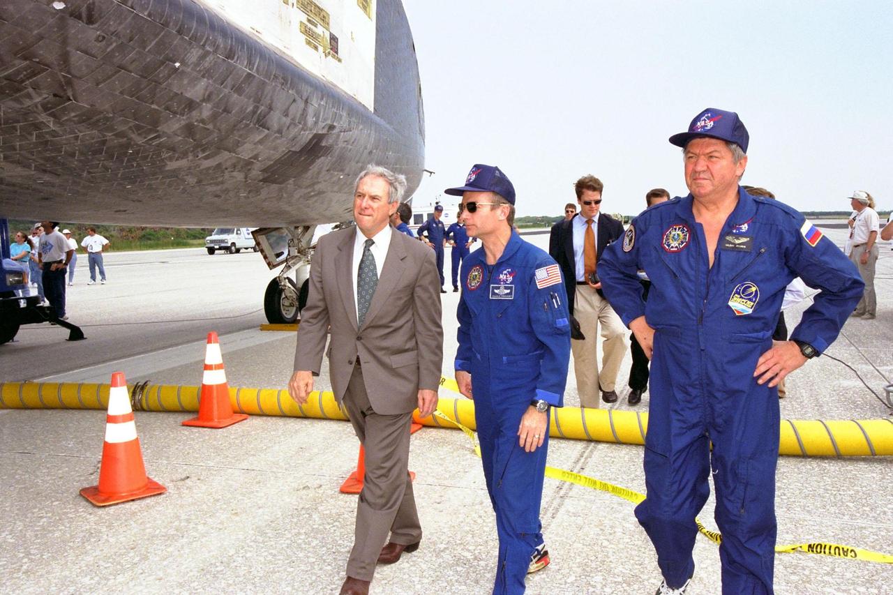 NASA Administrator Dan Goldin, STS-91 Mission Commander Charles J. Precourt, and STS-91 Mission Specialist Valery Victorovitch Ryumin of the Russian Space Agency inspect the orbiter Discovery after its landing at KSC's Shuttle Landing Facility, completing the STS-91 mission. Main gear touchdown occurred on Runway 15 at 2:00:18 p.m. EDT on June 12, 1998, on orbit 155 of the mission. The wheels stopped at 2:01:22 p.m. EDT, for a total mission-elapsed time of 9 days, 19 hours, 55 minutes and 1 second. The 91st Shuttle mission was the 44th KSC landing in the history of the Space Shuttle program and the 15th consecutive landing at KSC. During the mission, the Shuttle docked with the Russian space station Mir for the ninth time, concluding Phase I of the joint U.S.-Russian International Space Station Program. STS-91 also featured first flights for both the Alpha Magnetic Spectrometer and the Space Shuttle super lightweight external tank. The STS-91 flight crew also included Pilot Dominic L. Gorie and Mission Specialists Wendy B. Lawrence, Franklin R. Chang-Diaz, and Janet Lynn Kavandi. Astronaut Andrew S. W. Thomas also returned to Earth from Mir as an STS-91 crew member after 141 days in space