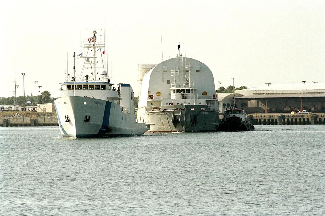 KENNEDY SPACE CENTER, FLA. -- Freedom Star, one of NASA's two solid rocket booster recovery ships, tows a barge containing the third Space Shuttle super lightweight external tank (SLWT) into Port Canaveral. This SLWT will be used to launch the orbiter Discovery on mission STS-95 in October. This first-time towing arrangement, part of a cost savings plan by NASA to prudently manage existing resources, began June 12 from the Michoud Assembly Facility in New Orleans where the Shuttle's external tanks are manufactured. The barge will now be transported up the Banana River to the LC-39 turn basin using a conventional tugboat. Previously, NASA relied on an outside contractor to provide external tank towing services at a cost of about $120,000 per trip. The new plan allows NASA's Space Flight Operations contractor, United Space Alliance (USA), to provide the same service directly to NASA using the recovery ships during their downtime between Shuttle launches. Studies show a potential savings of about $50,000 per trip. The cost of the necessary ship modifications should be paid back by the fourteenth tank delivery. The other recovery ship, Liberty Star, has also undergone deck strengthening enhancements and will soon have the necessary towing winch installed