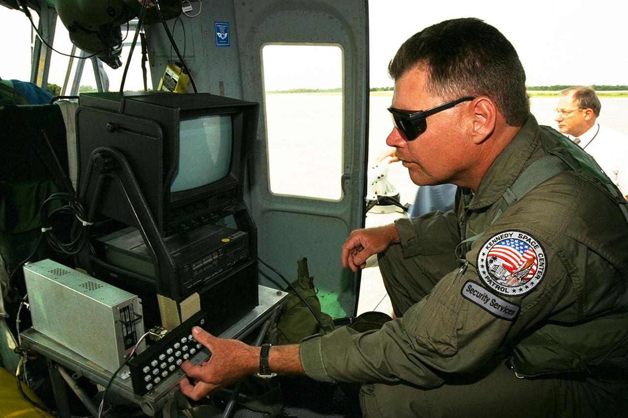 KENNEDY SPACE CENTER, FLA. --  Sgt. Mark Hines, of Kennedy Space Center (KSC) Security, checks out equipment used to operate the Forward Looking Infrared Radar (FLIR) installed on NASA's Huey UH-1 helicopter. The helicopter has also been outfitted with a portable global positioning satellite (GPS) system to support Florida's Division of Forestry as they fight the brush fires which have been plaguing the state as a result of extremely dry conditions and lightning storms. The FLIR includes a beach ball-sized infrared camera that is mounted on the helicopter's right siderail and a real-time television monitor and recorder installed inside. While the FLIR collects temperature data and images, the GPS system provides the exact coordinates of the fires being observed and transmits the data to the firefighters on the ground. KSC's security team routinely uses the FLIR equipment prior to Shuttle launch and landing activities to ensure that the area surrounding the launch pad and runway are clear of unauthorized personnel. KSC's Base Operations Contractor, EG&G Florida, operates the NASA-owned helicopter
