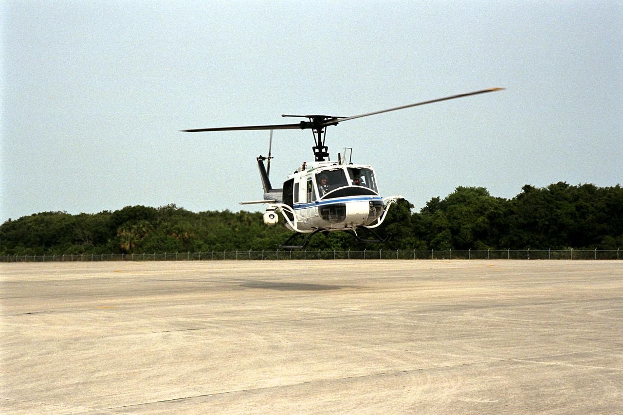 KENNEDY SPACE CENTER, FLA. --  NASA's Huey UH-1 helicopter lands at the Shuttle Landing Facility to pick up Kennedy Space Center (KSC) Security personnel who operate the Forward Looking Infrared Radar (FLIR) installed on board. The helicopter has also been outfitted with a portable global positioning satellite (GPS) system to support Florida's Division of Forestry as they fight the brush fires which have been plaguing the state as a result of extremely dry conditions and lightning storms. The FLIR includes a beach ball-sized infrared camera that is mounted on the helicopter's right siderail and a real-time television monitor and recorder installed inside. While the FLIR collects temperature data and images, the GPS system provides the exact coordinates of the fires being observed and transmits the data to the firefighters on the ground. KSC's security team routinely uses the FLIR equipment prior to Shuttle launch and landing activities to ensure that the area surrounding the launch pad and runway are clear of unauthorized personnel. KSC's Base Operations Contractor, EG&G Florida, operates the NASA-owned helicopter