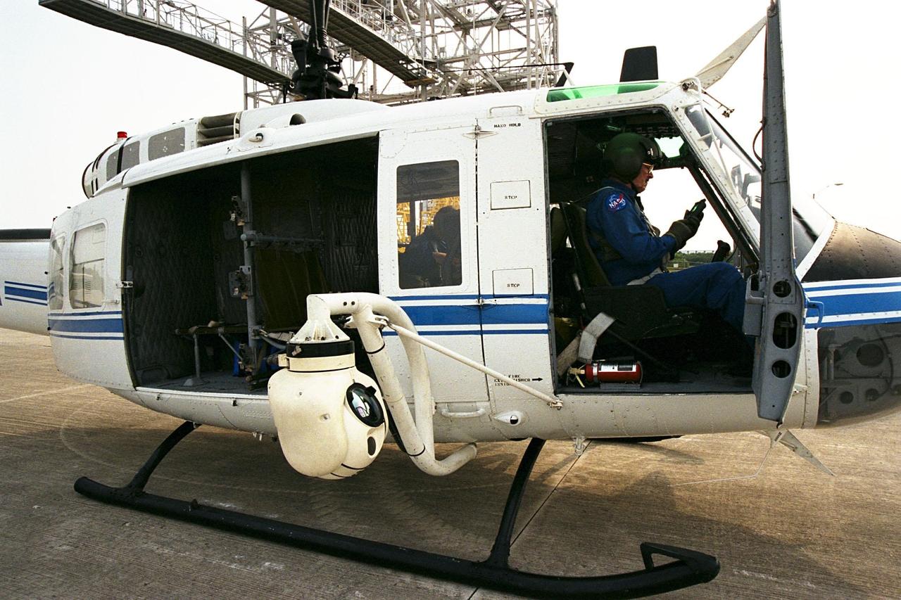 KENNEDY SPACE CENTER, FLA. --  A beach ball-sized infrared camera, part of the Forward Looking Infrared Radar (FLIR), has been mounted on the right siderail of NASA's Huey UH-1 helicopter. A KSC pilot prepares to fly the helicopter, which has also been outfitted with a portable global positioning satellite (GPS) system, to support Florida's Division of Forestry as they fight the brush fires which have been plaguing the state as a result of extremely dry conditions and lightning storms. The FLIR also includes a real-time television monitor and recorder installed inside the helicopter. While the FLIR collects temperature data and images, the GPS system provides the exact coordinates of the fires being observed and transmits the data to the firefighters on the ground. The Kennedy Space Center (KSC) security team routinely uses the FLIR equipment prior to Shuttle launch and landing activities to ensure that the area surrounding the launch pad and runway are clear of unauthorized personnel. KSC's Base Operations Contractor, EG&G Florida, operates the NASA-owned helicopter