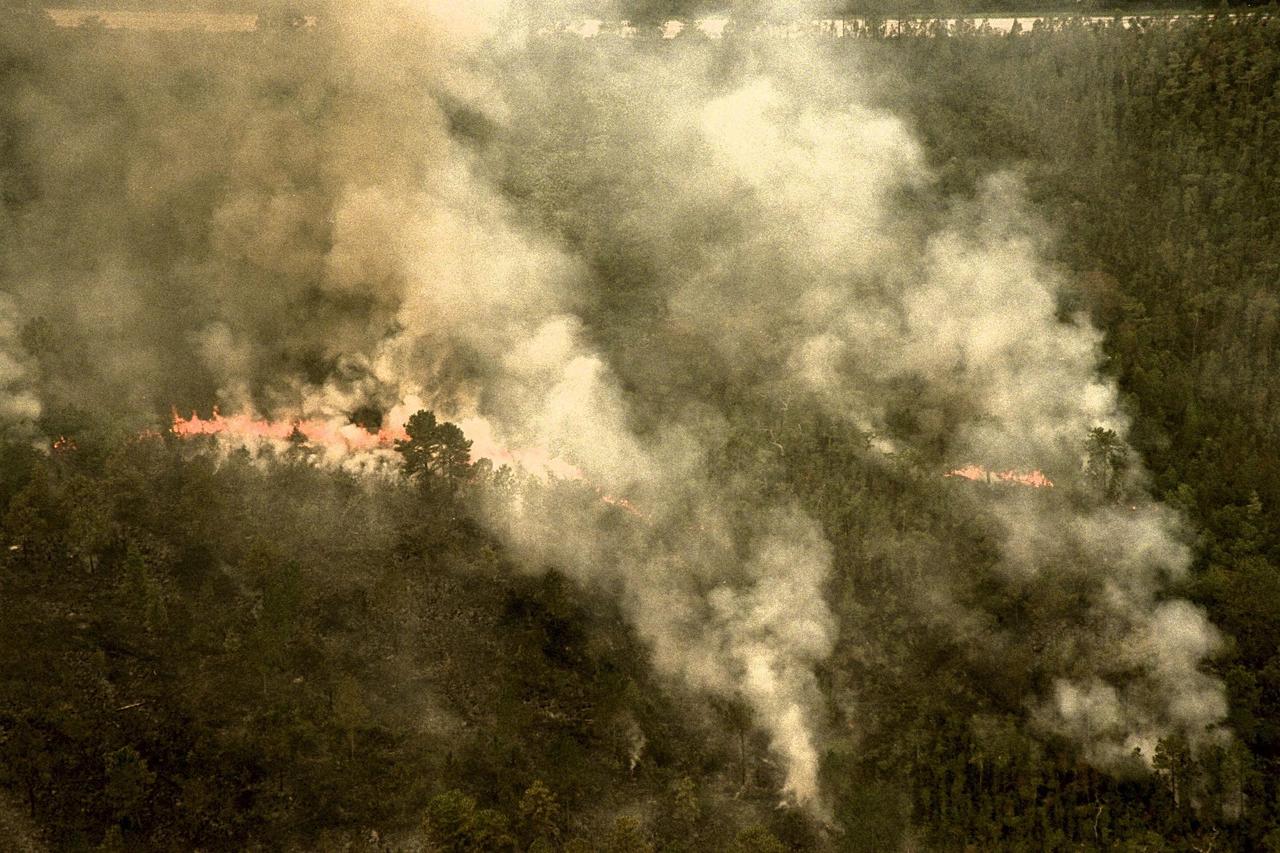 KENNEDY SPACE CENTER, FLA. --  A forest fire burning in Volusia County, Florida, is clearly visible from NASA's Huey UH-1 helicopter. The helicopter has been outfitted with a Forward Looking Infrared Radar (FLIR) and a portable global positioning satellite (GPS) system to support Florida's Division of Forestry as they fight the brush fires which have been plaguing the state as a result of extremely dry conditions and lightning storms. The FLIR includes a beach ball-sized infrared camera that is mounted on the helicopter's right siderail and a real-time television monitor and recorder installed inside. While the FLIR collects temperature data and images, the GPS system provides the exact coordinates of the fires being observed and transmits the data to the firefighters on the ground. The Kennedy Space Center (KSC) security team routinely uses the FLIR equipment prior to Shuttle launch and landing activities to ensure that the area surrounding the launch pad and runway are clear of unauthorized personnel. KSC's Base Operations Contractor, EG&G Florida, operates the NASA-owned helicopter