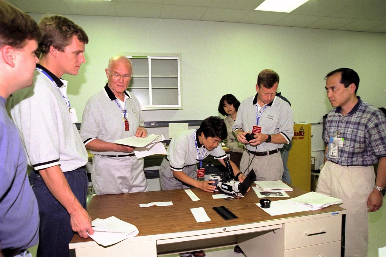 STS-95 crew members (from left) Mission Specialists Scott E. Parazynski, Payload Specialist John H. Glenn Jr., Payload Specialist Chiaki Mukai, representing the National Space Development Agency of Japan (NASDA), and Pilot Steven W. Lindsey look over equipment that Hideo Ishikawa of NASDA has presented at SPACEHAB Payload Processing Facility, Cape Canaveral, Fla. The STS-95 crew is at KSC to look at the SPACEHAB module and the equipment that will fly with them on the Space Shuttle Discovery, scheduled to launch Oct. 29, 1998. The mission includes research payloads such as the Spartan solar-observing deployable spacecraft, the Hubble Space Telescope Orbital Systems Test Platform, the International Extreme Ultraviolet Hitchhiker, as well as the SPACEHAB single module with experiments on space flight and the aging process