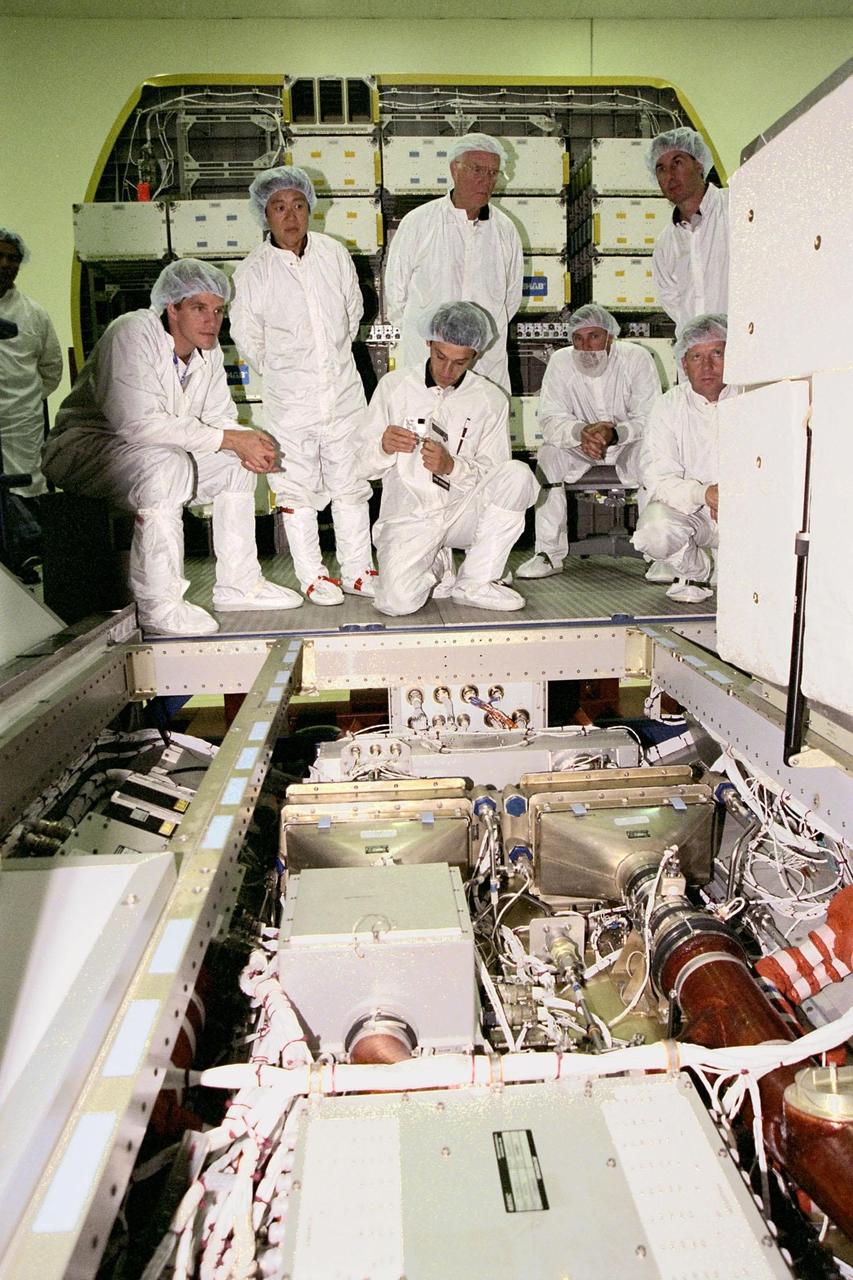 STS-95 crew members (from left) Mission Specialist Scott E. Parazynski, Payload Specialists Chiaki Mukai and John H. Glenn Jr., Mission Specialist Pedro Duque (kneeling in front center), Commander Curtis L. Brown Jr., Mission Specialist Stephen K. Robinson and Pilot Steven W. Lindsey (kneeling at right) look at the inside of the SPACEHAB module at the SPACEHAB Payload Processing Facility, Cape Canaveral, Fla. The crew is on a familiarization tour of the module and equipment that will fly with them on the Space Shuttle Discovery scheduled to launch Oct. 29, 1998. The mission includes research payloads such as the Spartan solar-observing deployable spacecraft, the Hubble Space Telescope Orbital Systems Test Platform, the International Extreme Ultraviolet Hitchhiker, as well as the SPACEHAB single module with experiments on space flight and the aging process