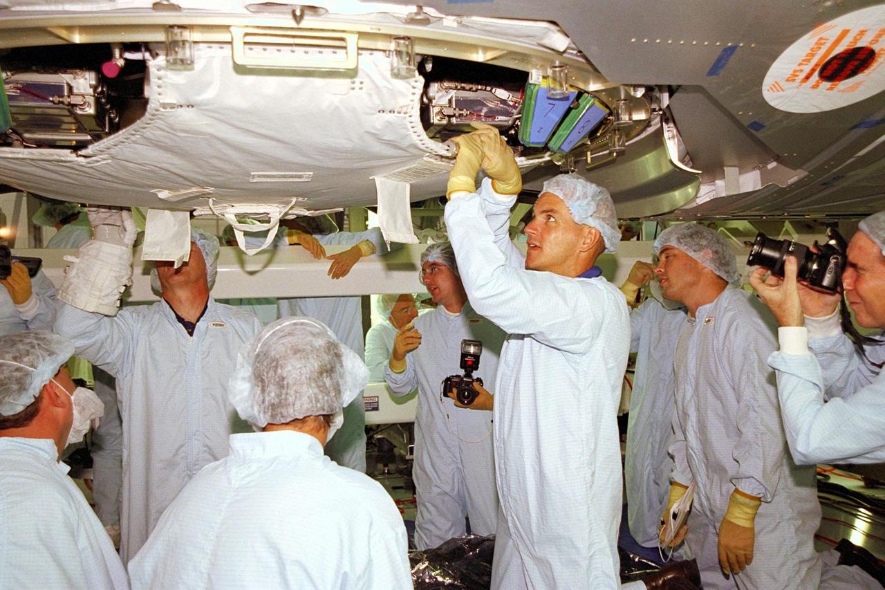KENNEDY SPACE CENTER, FLA. -- STS-88 crew members and technicians watch as Pilot Rick W. Sturckow inspects equipment on the Unity connecting module, part of the International Space Station, in the Space Station Processing Facility at KSC. During the mission, the Unity connecting module will be mated to the Zarya control module, which will already be in orbit. The STS-88 crew is participating in a Crew Equipment Interface Test, which gives astronauts an opportunity for a hands-on look at the payloads on which they will be working while on orbit. STS-88 will be the first Space Shuttle launch for the International Space Station. Launch is scheduled for December 1998