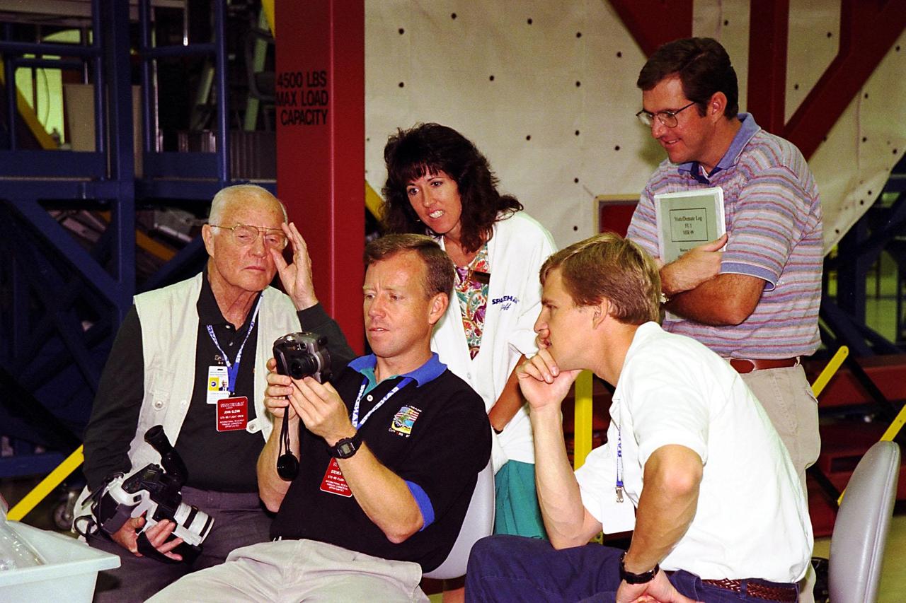 KENNEDY SPACE CENTER, FLA. -- STS-95 crew members check out camera equipment they will use on the mission during a SPACEHAB familiarization tour and briefing at the SPACEHAB Payload Processing Facility in Cape Canaveral. Seated, from left, are Payload Specialist John H. Glenn Jr., who also is a senator from Ohio; Pilot Steven W. Lindsey; and Mission Specialist Scott E. Parazynski. Standing in back are Boeing employees LaDonna Neterer and Scott Clark. STS-95 will feature a variety of research payloads, including the Spartan solar-observing deployable spacecraft, the Hubble Space Telescope Orbital Systems Platform, the International Extreme Ultraviolet Hitchhiker, and experiments on space flight and the aging process. STS-95 is targeted for an Oct. 29 launch aboard the Space Shuttle Discovery