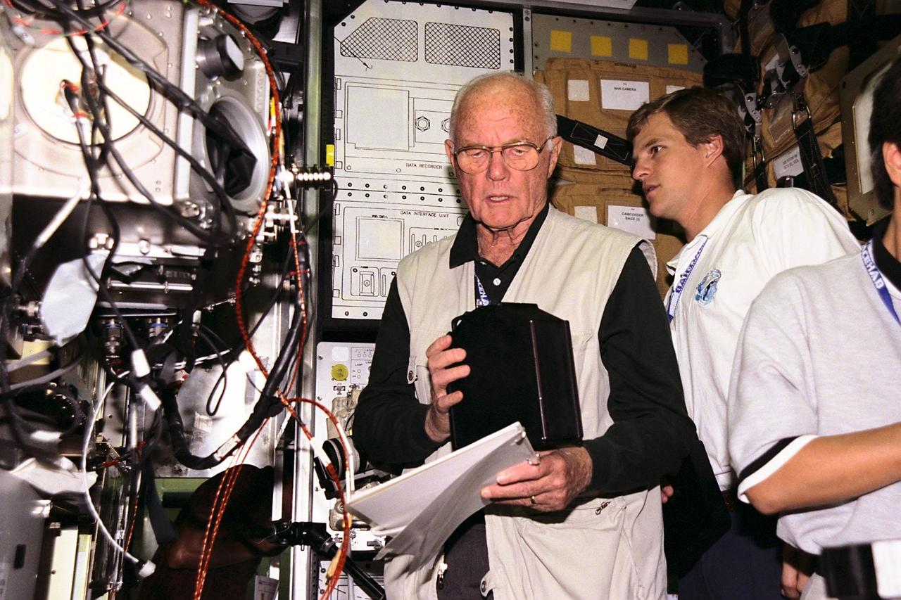 KENNEDY SPACE CENTER, FLA. -- STS-95 Mission Specialist Scott E. Parazynski, at center, takes some experiment equipment from Payload Specialist John H. Glenn Jr., while in the SPACEHAB trainer at the SPACEHAB Payload Processing Facility in Cape Canaveral. Payload Specialist Chiaki Mukai, representing the National Space Development Agency of Japan (NASDA), sets up a camera in the foreground. STS-95 will feature a variety of research payloads, including the Spartan solar-observing deployable spacecraft, the Hubble Space Telescope Orbital Systems Platform, the International Extreme Ultraviolet Hitchhiker, and experiments on space flight and the aging process. STS-95 is targeted for an Oct. 29 launch aboard the Space Shuttle Discovery